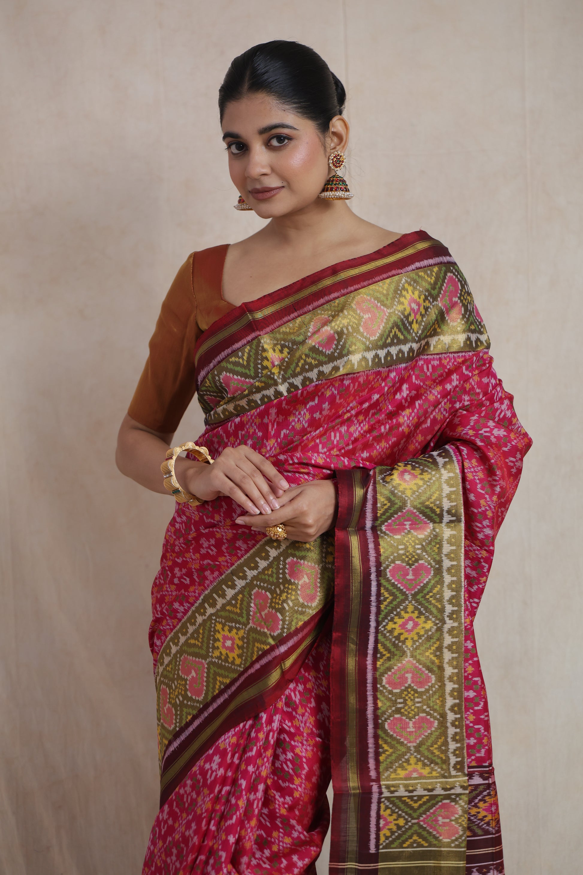 Close-up of woven olive green border on rani pink Patola silk saree