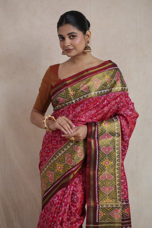 Close-up of woven olive green border on rani pink Patola silk saree