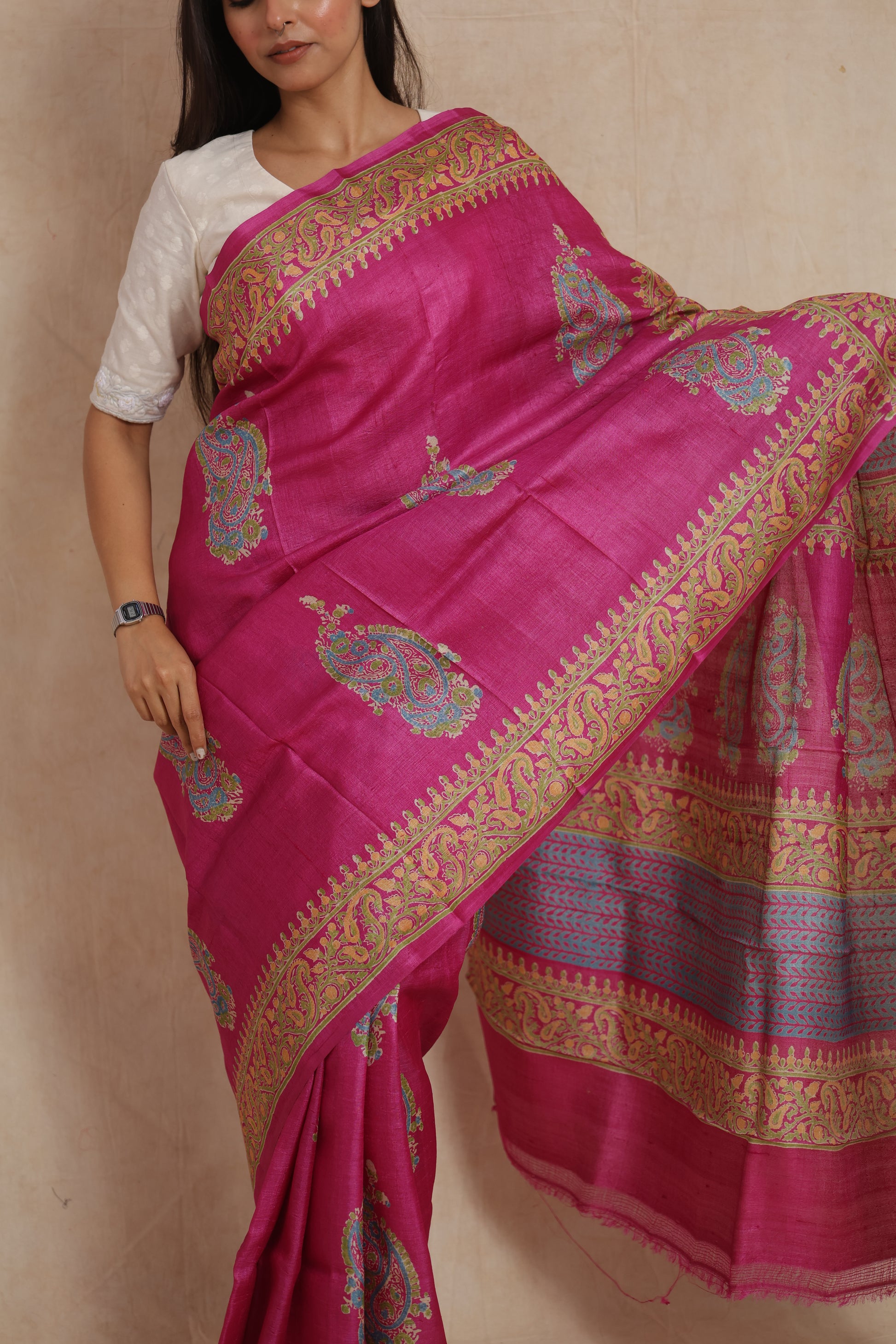 Close-up view of rani pink Tussar print saree with paisley motifs and ornate borders