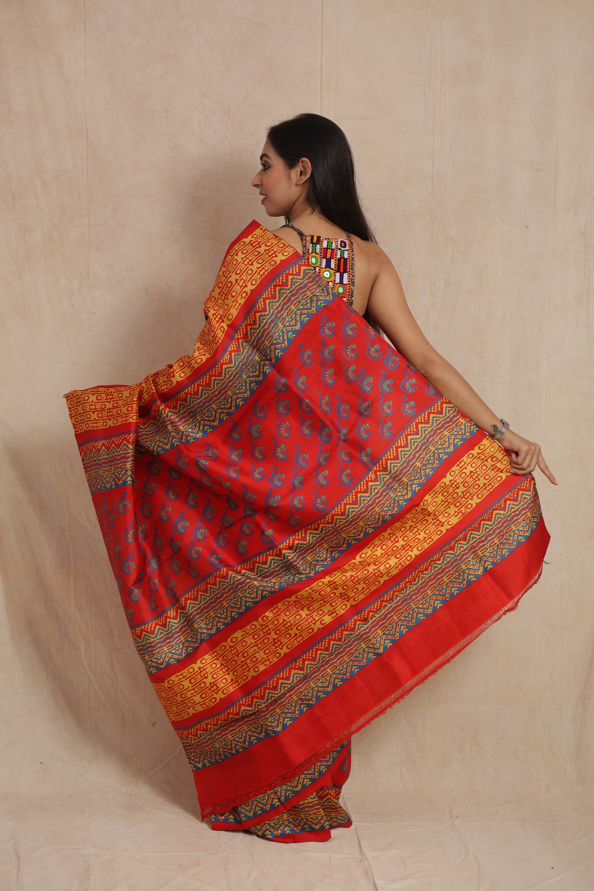 Back pallu view of royal red Batik silk saree featuring tribal-inspired woven patterns