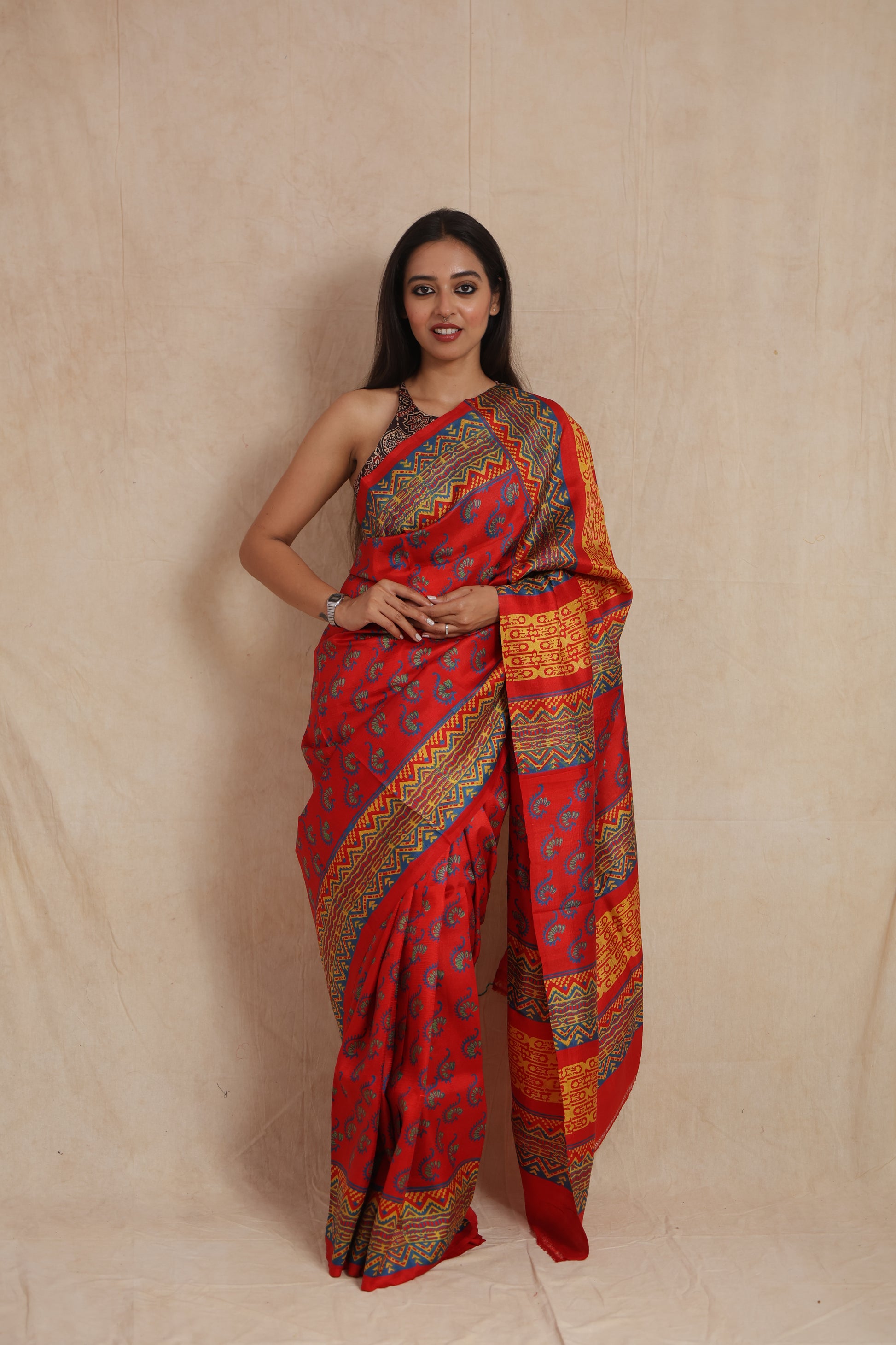 Front drape view of royal red Batik silk saree with geometric woven patterns
