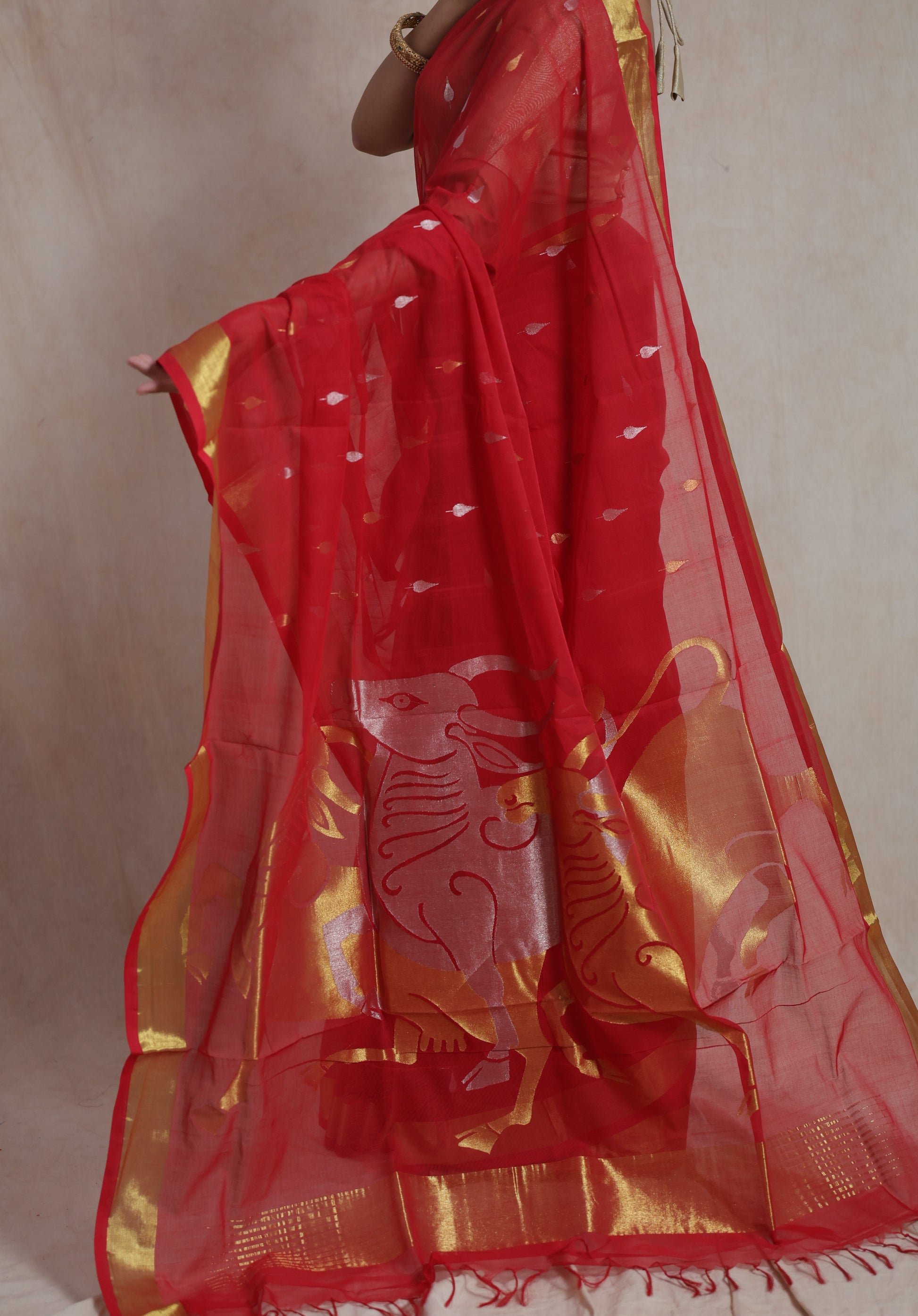 Close up of red Kanchipuram cotton saree with woven artistic motifs