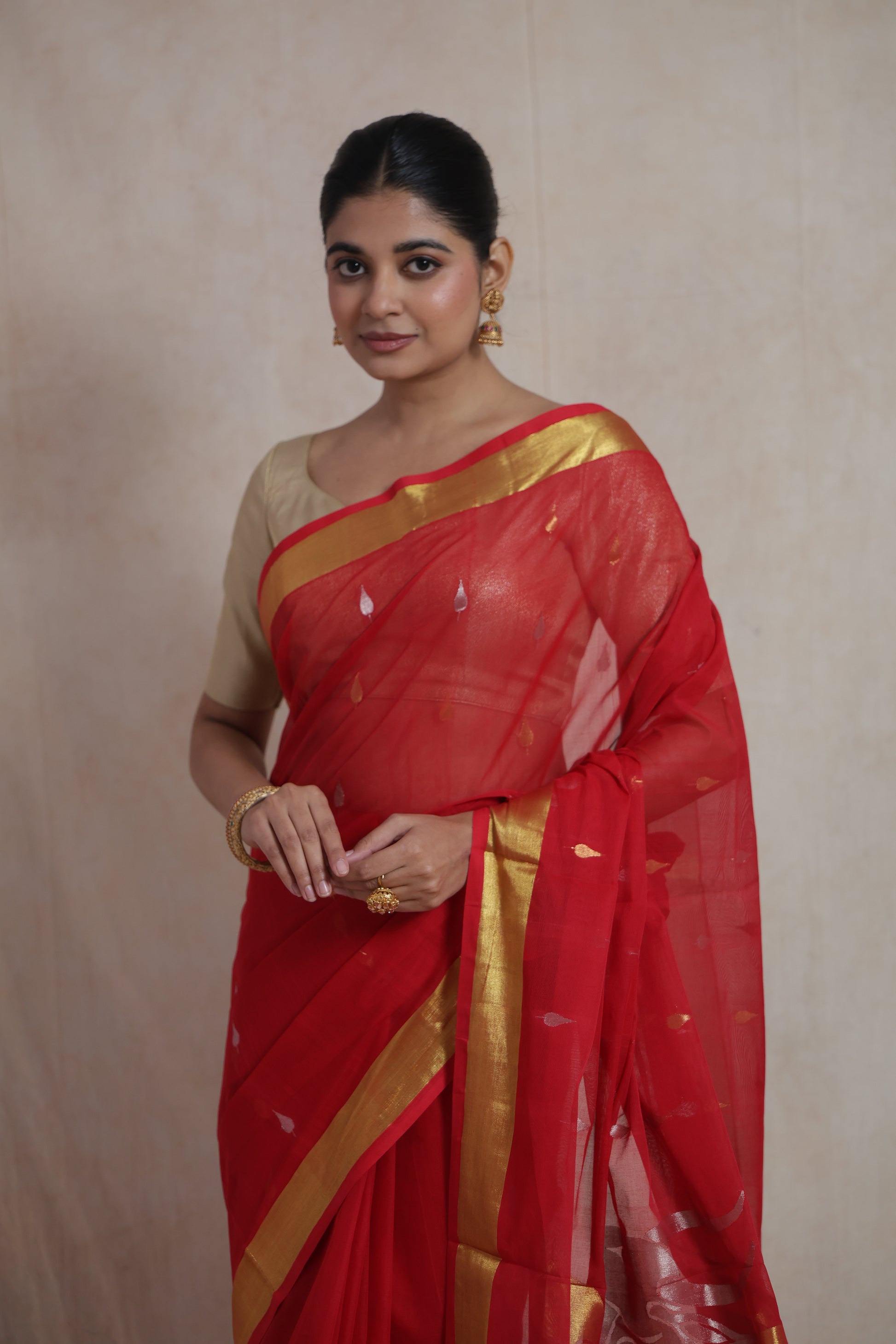 Model wearing red Kanchipuram cotton saree with gold woven border