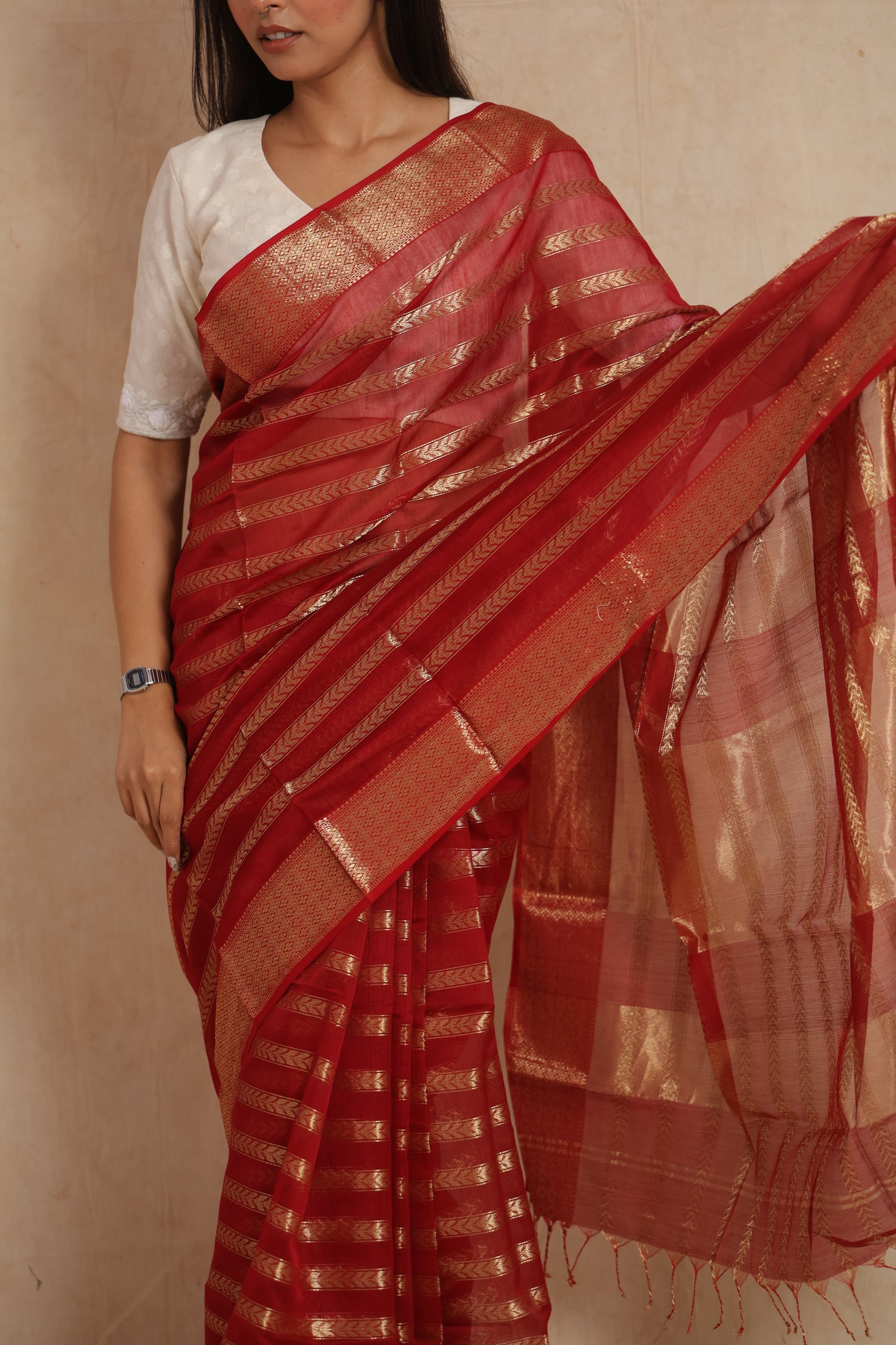Close-up of red Maheshwari silk tissue saree with gold striped weaving