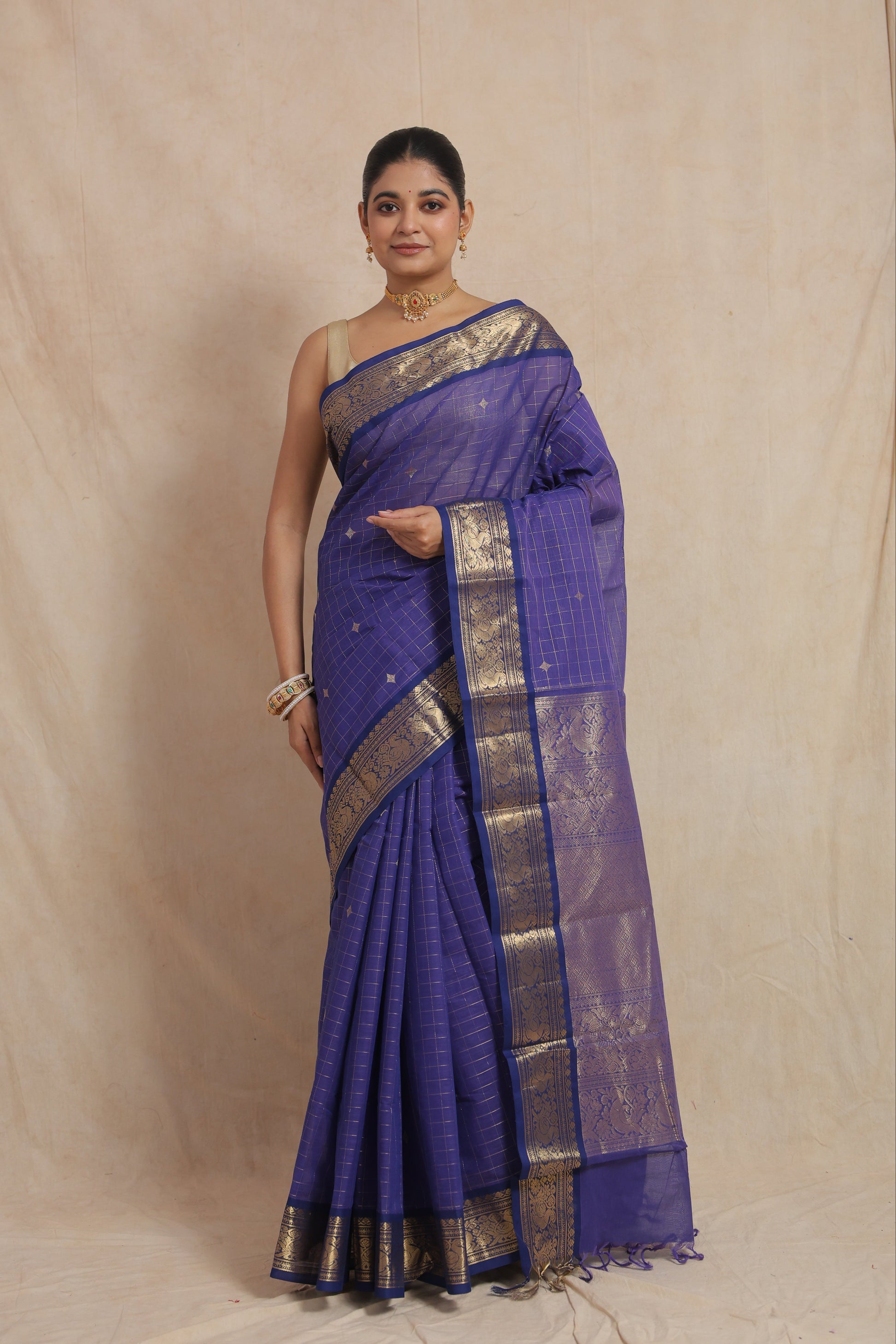 Model wearing royal blue Kanchipuram cotton saree with woven border