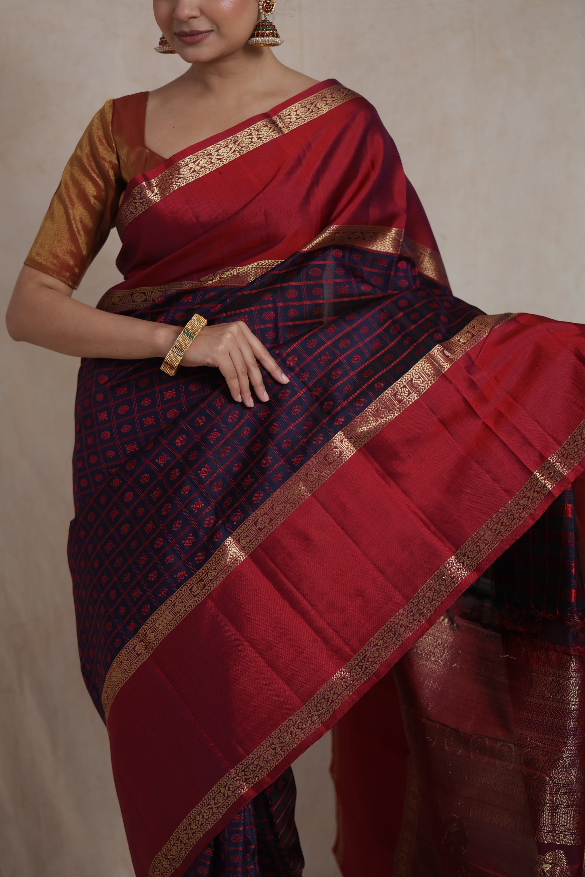 Model wearing royal crimson and navy blue Kanjivaram silk saree with zari border
