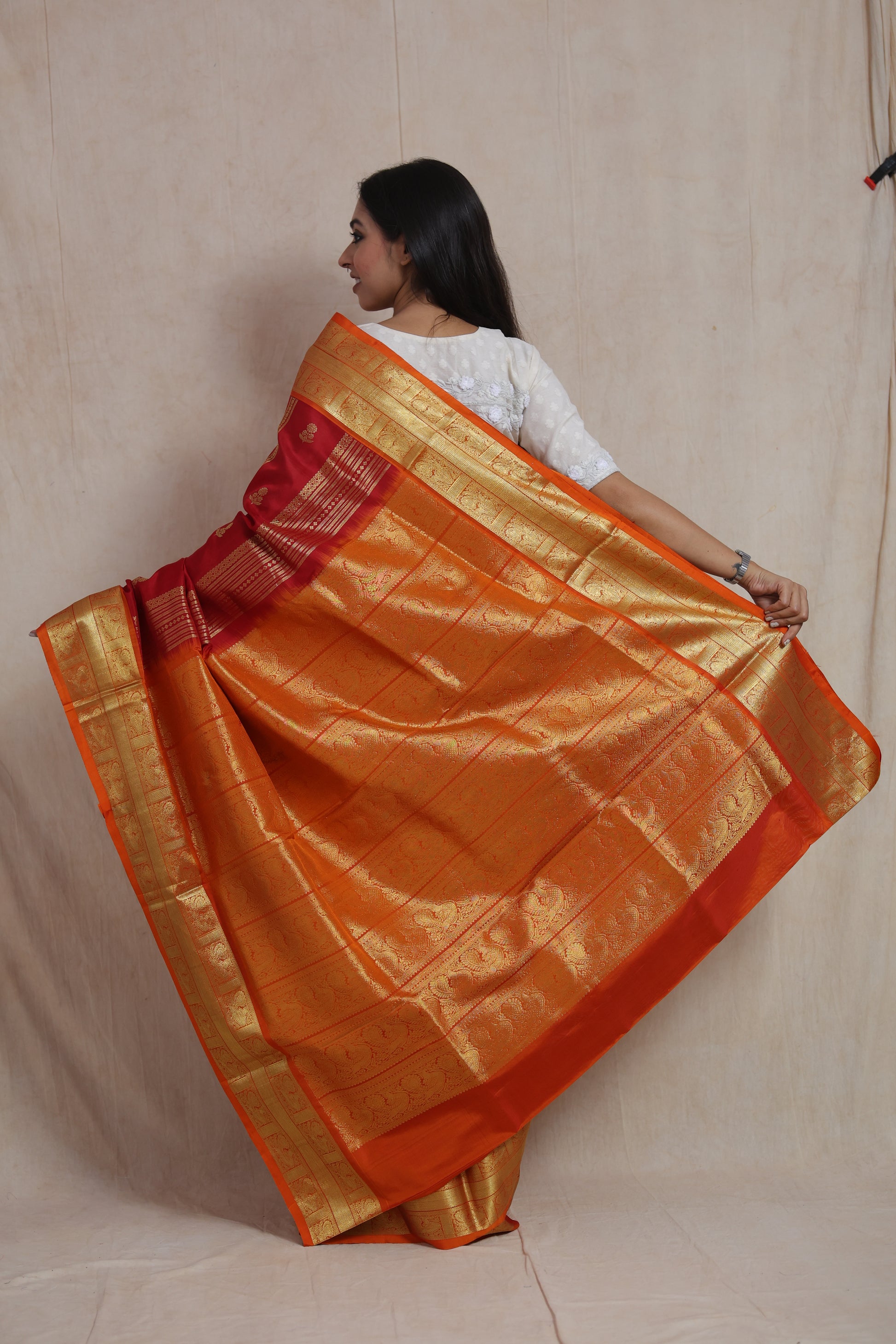 Back view of royal crimson and orange Venkatgiri handloom silk saree with richly woven pallu