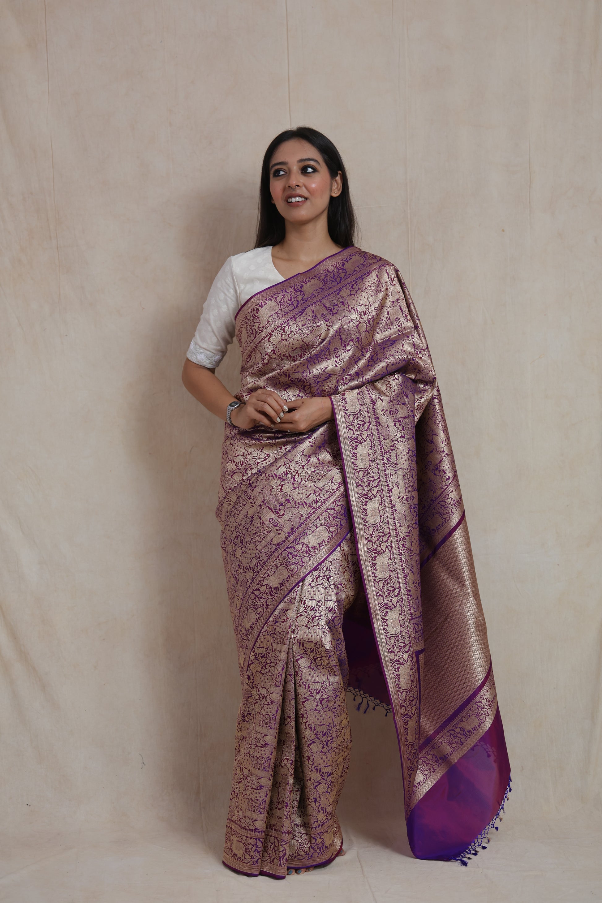 Elegant drape of royal purple Banarasi silk saree featuring rich woven zari motifs.