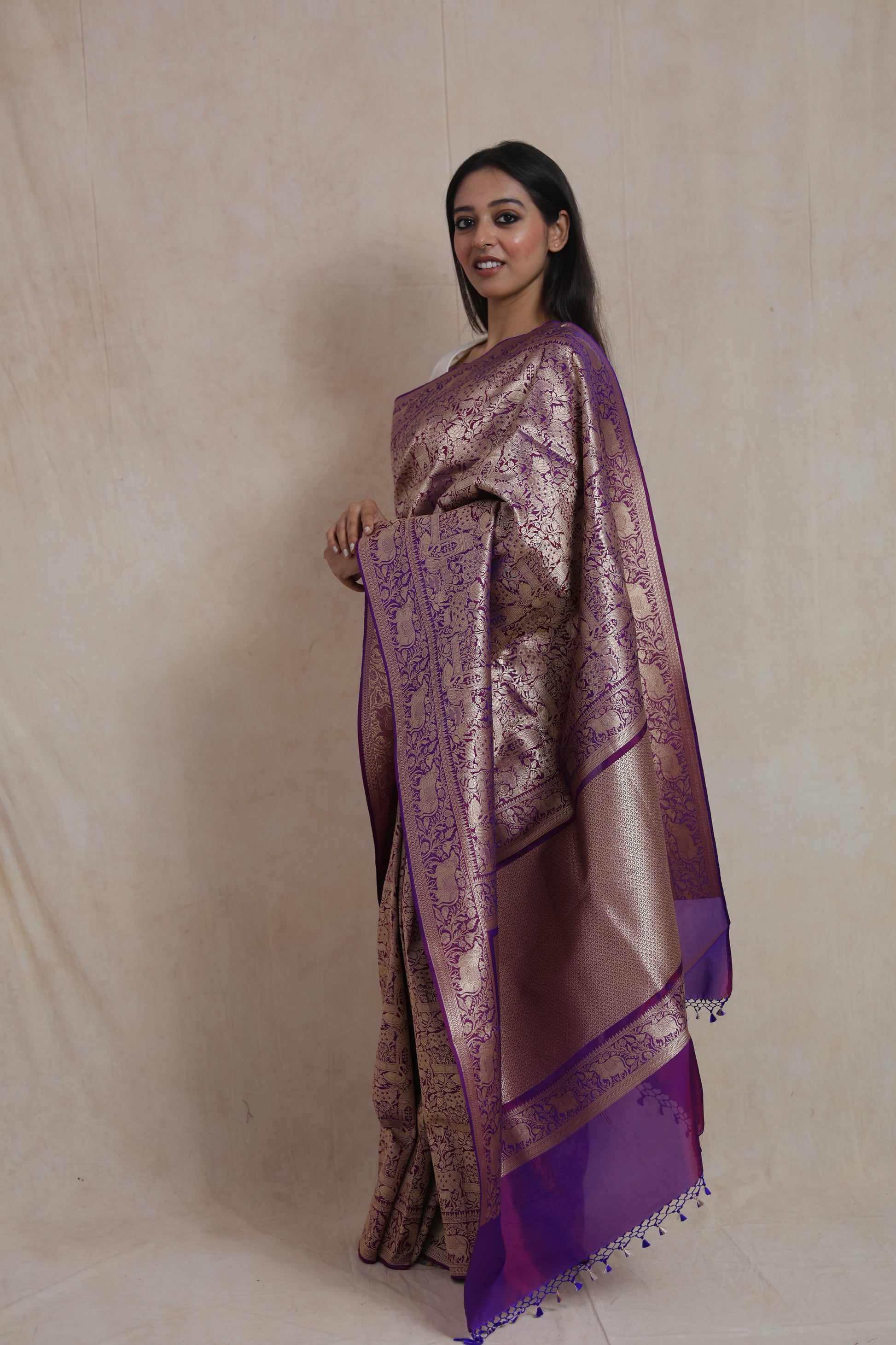 Side profile of handcrafted royal purple Banarasi saree with antique gold zari border.
