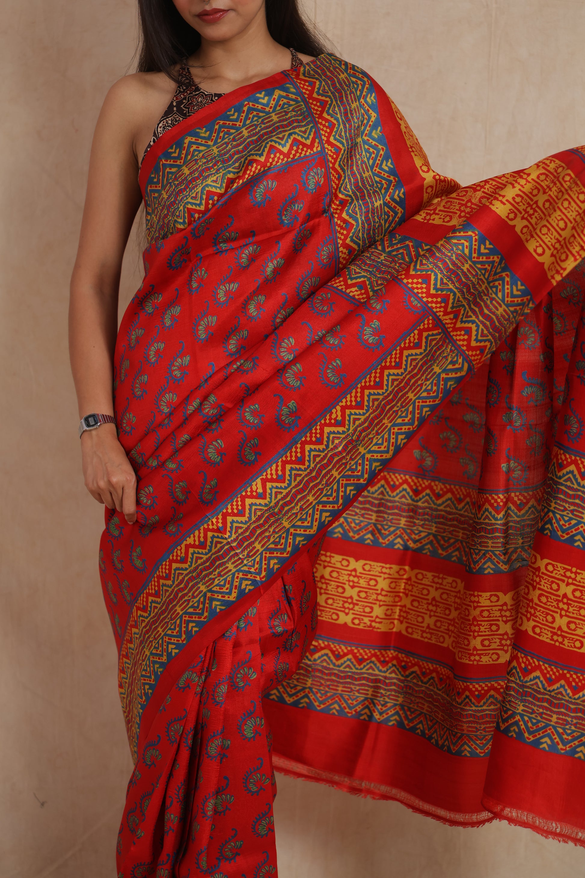 Close-up view of royal red Batik silk saree with paisley motifs and tribal borders