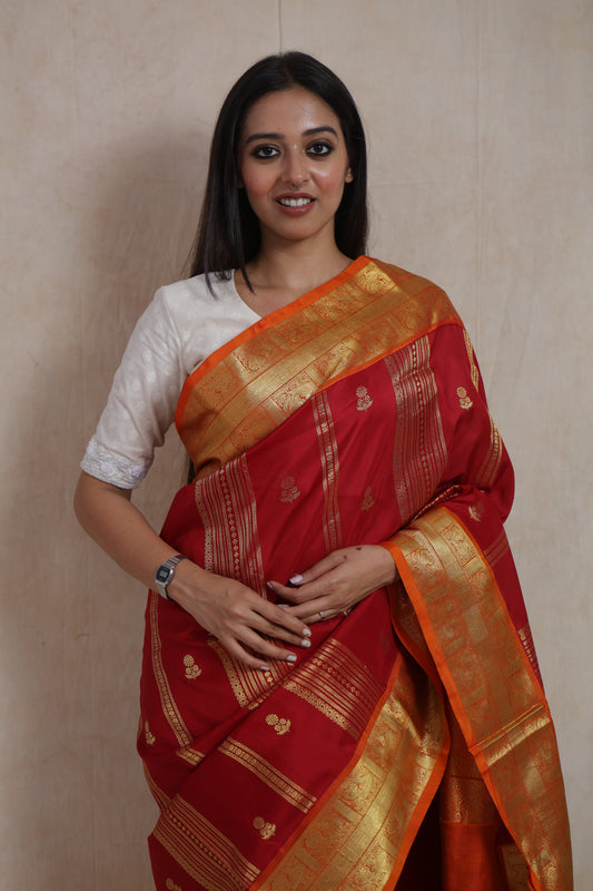 Front view of royal crimson Venkatgiri handloom silk saree with orange woven border