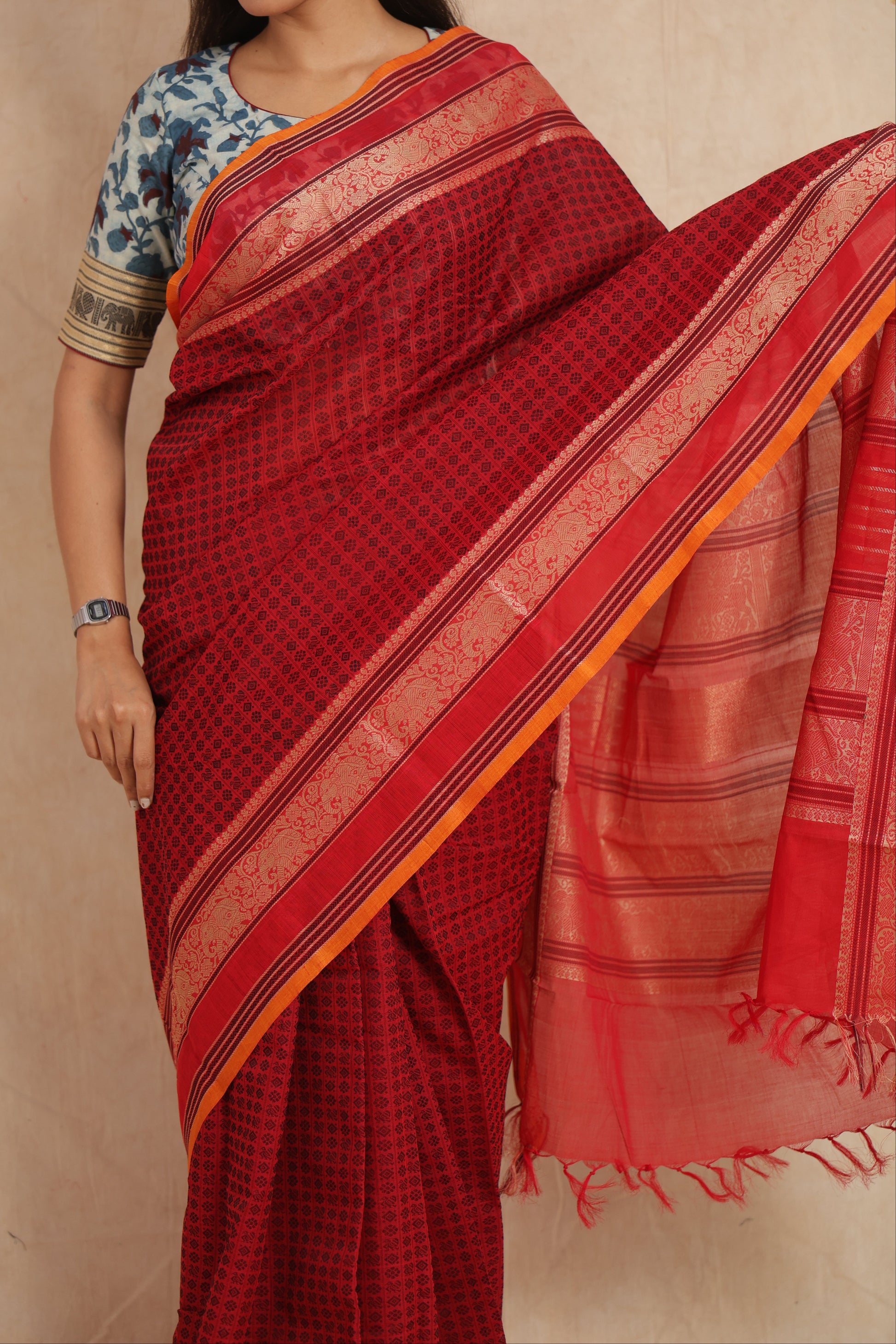 Close-up of ruby red Kanchipuram cotton saree with traditional woven border