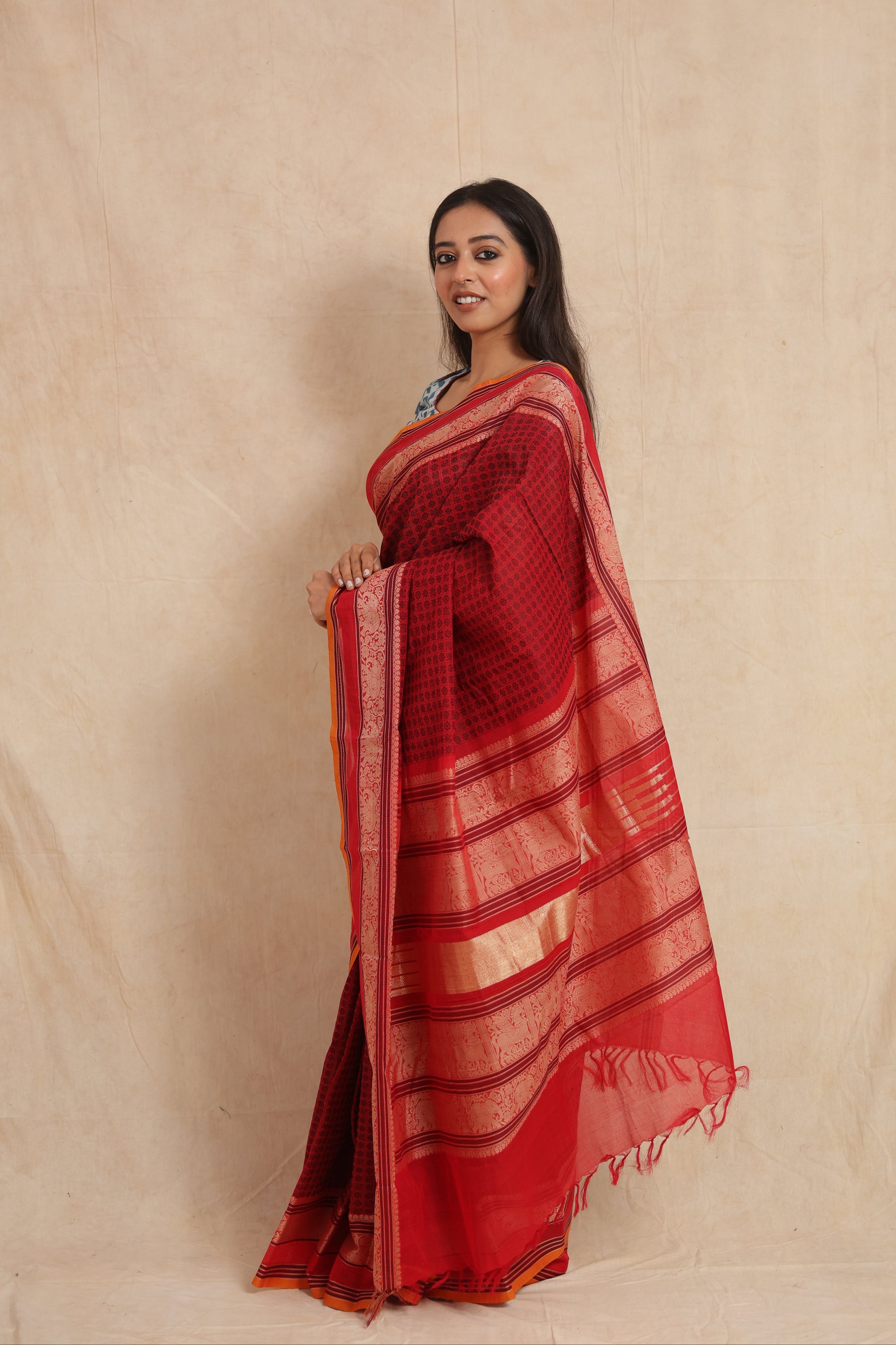 Side profile of ruby red Kanchipuram cotton saree with traditional border detailing