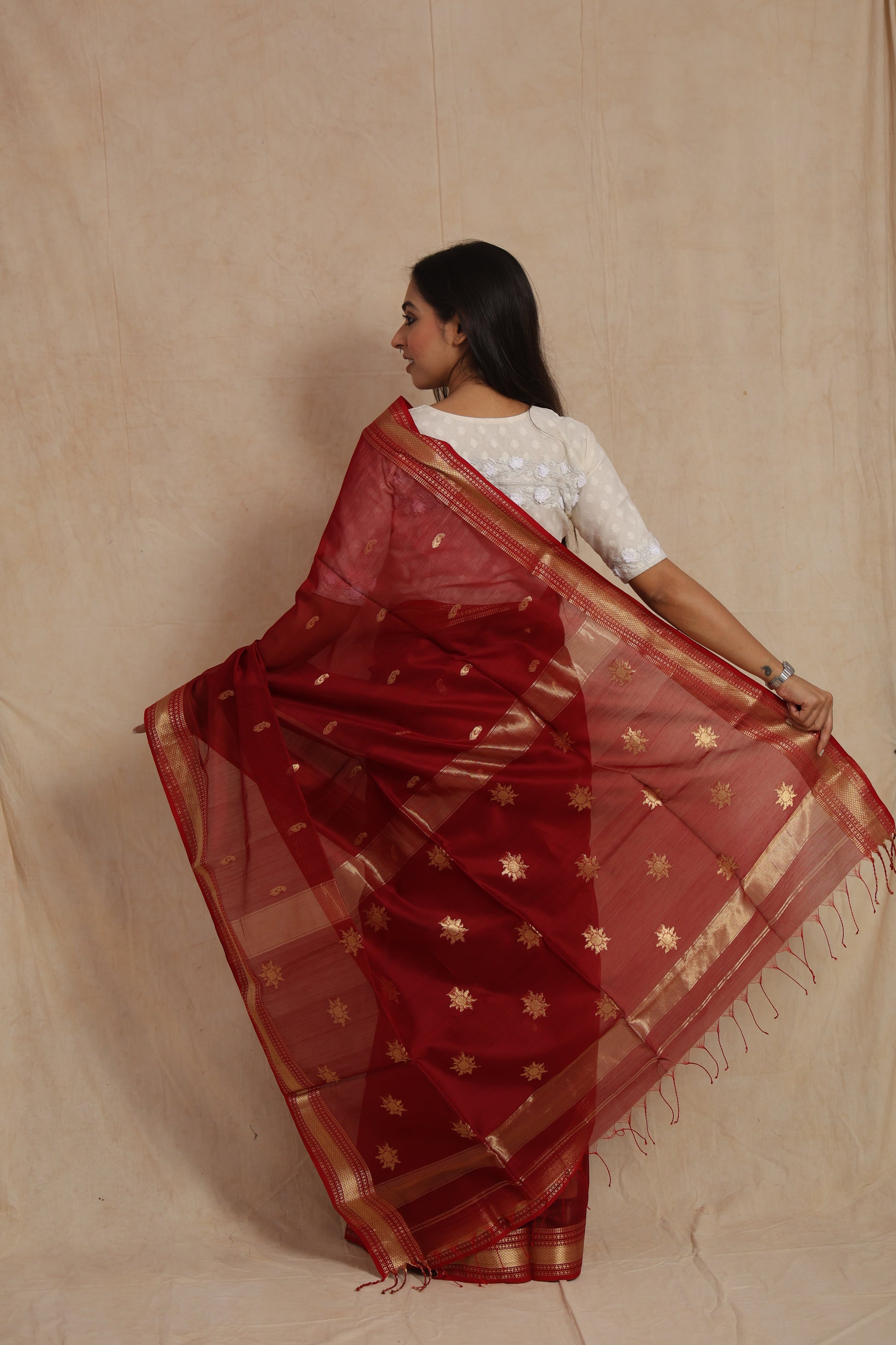 Back pallu view of ruby red Maheshwari handloom silk cotton saree with golden woven motifs