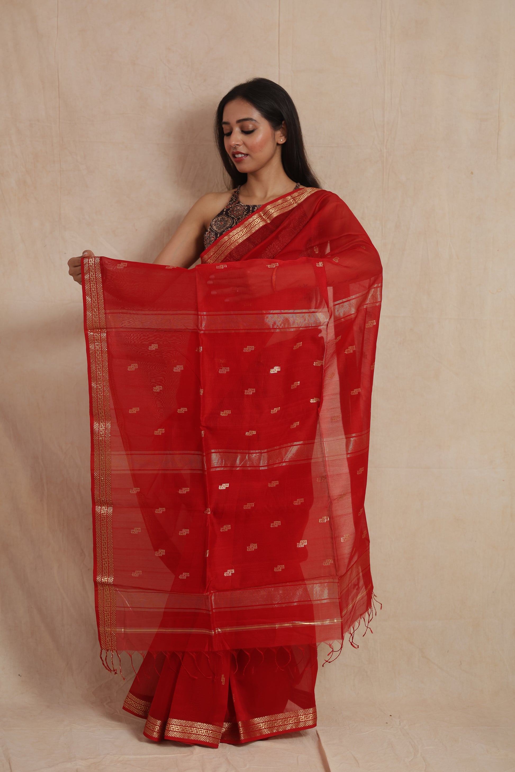 Display of ruby red Maheshwari Sico saree pallu with woven buttas