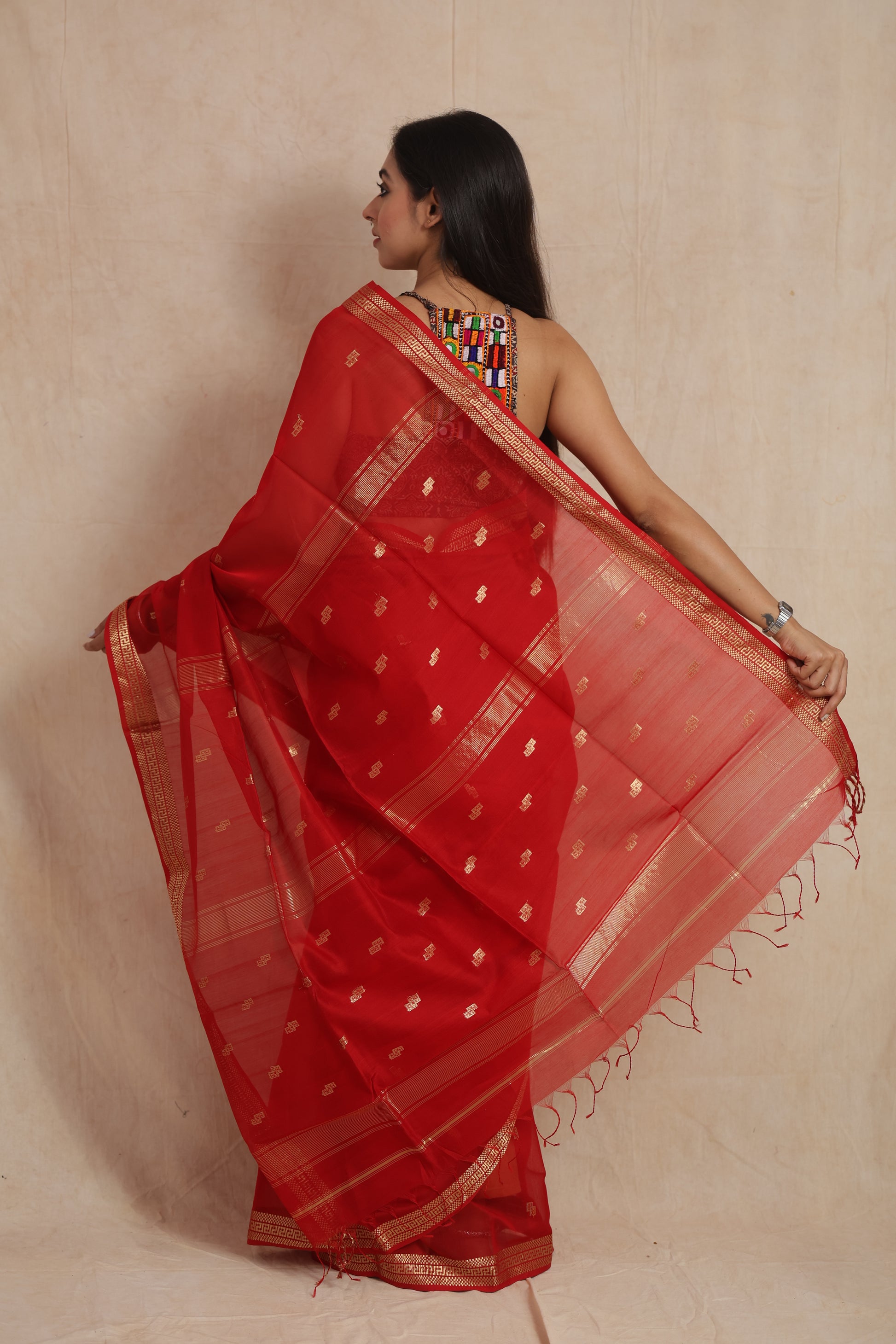 Side view of ruby red Maheshwari Sico saree with golden border