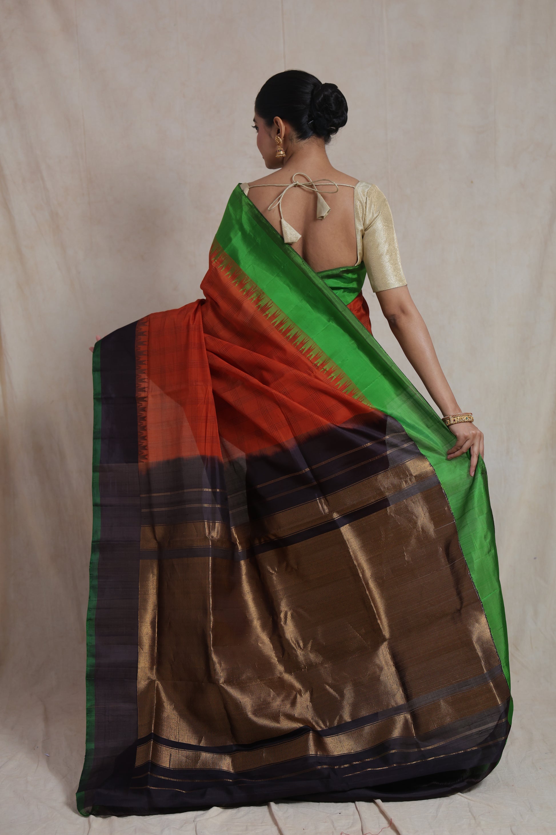 Back view of rust orange Gadwal Sico saree with emerald green border and rich pallu