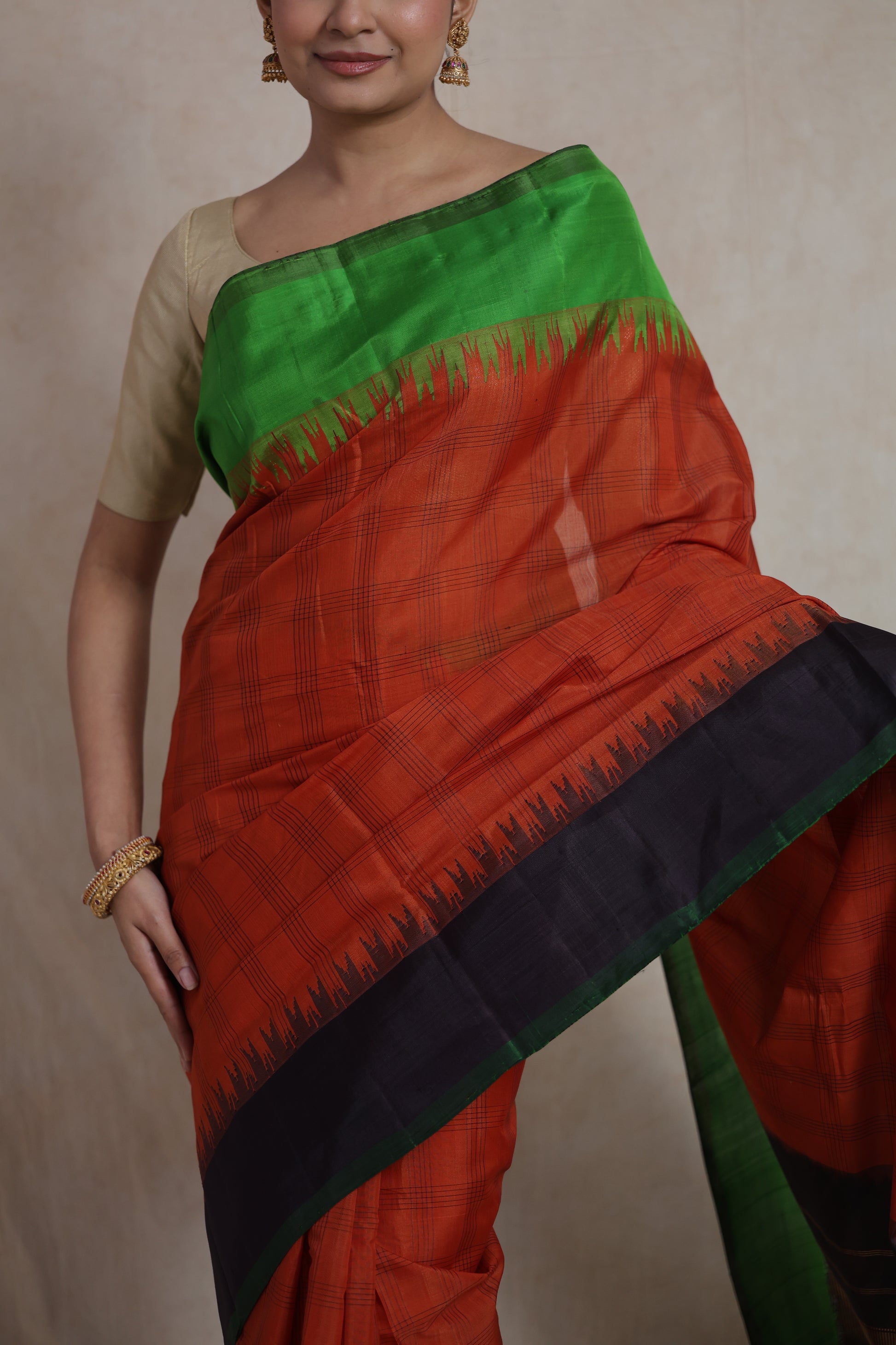 Close-up drape detail of rust orange Gadwal Sico saree with contrast border