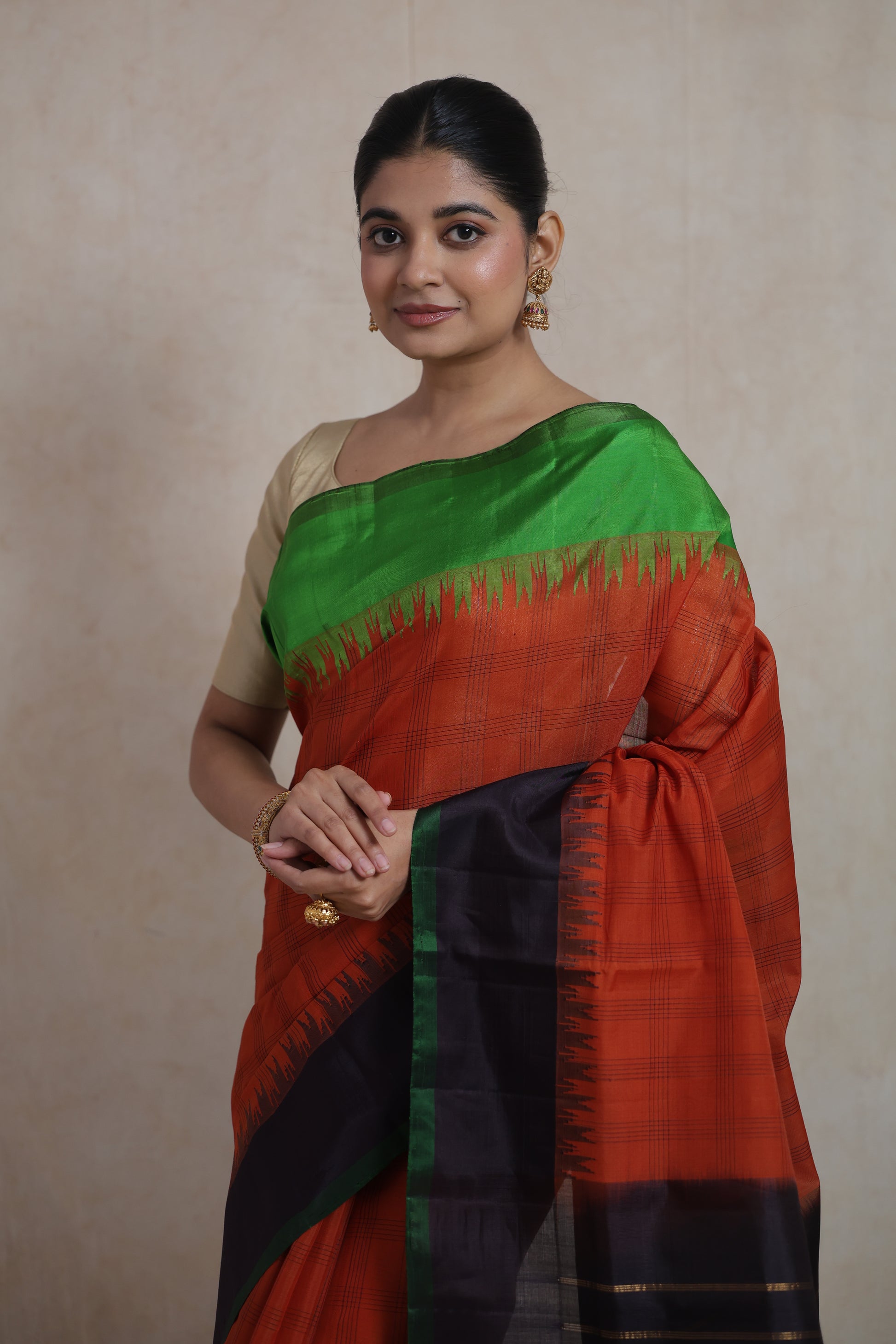 Portrait view of rust orange Gadwal Sico saree with emerald green contrast border