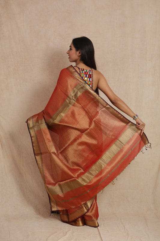 Back pallu display of rust orange Maheshwari tissue saree