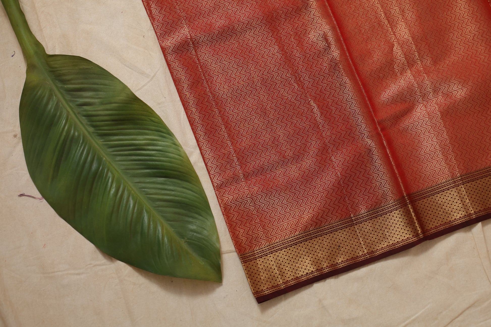Border detail of rust orange Maheshwari tissue saree with zari weave