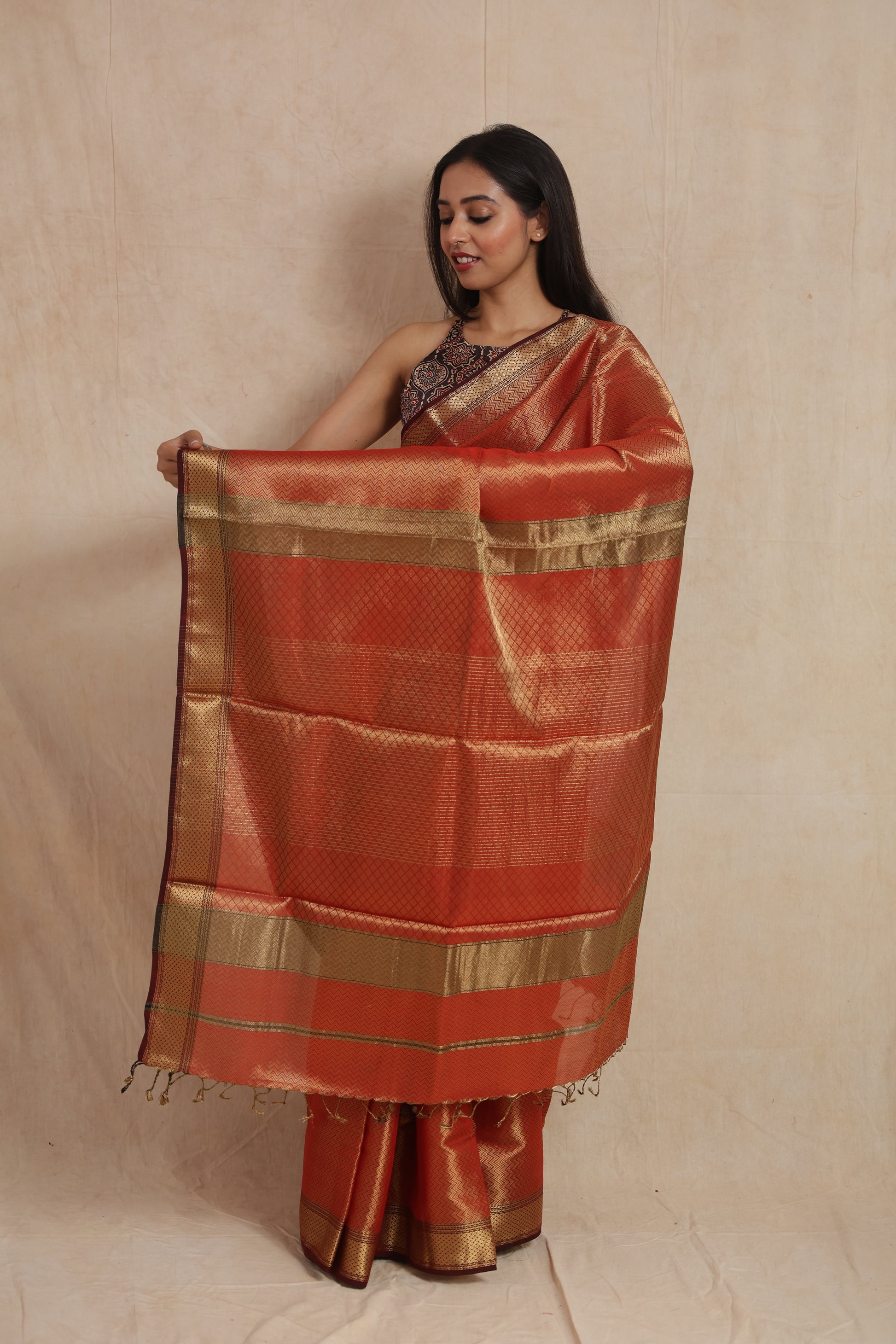 Full pallu display of rust orange Maheshwari tissue saree