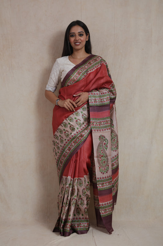Front view of rust rose Tussar print saree with floral paisley borders