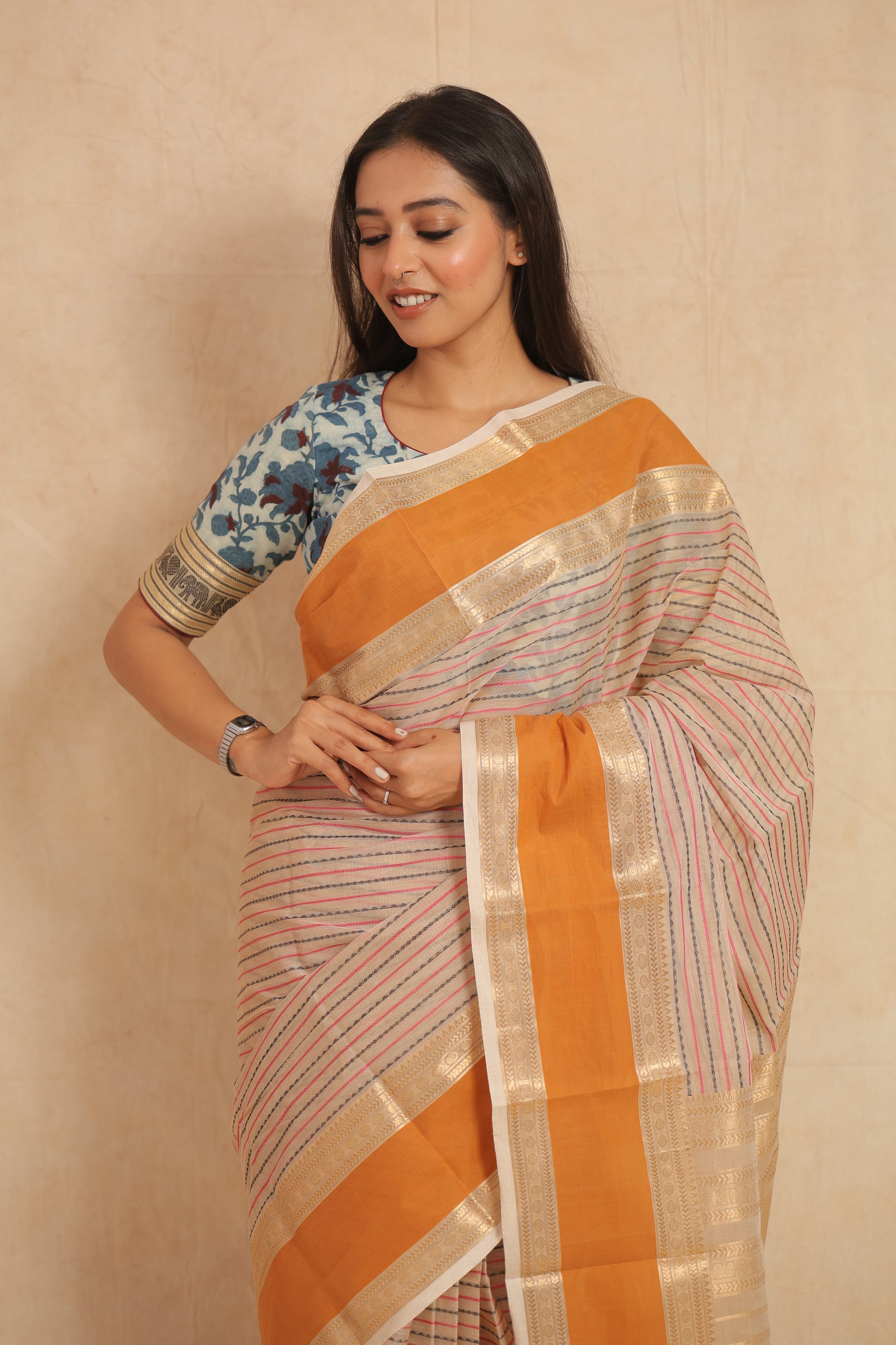 Saree pleats detail with orange border and zari weaving