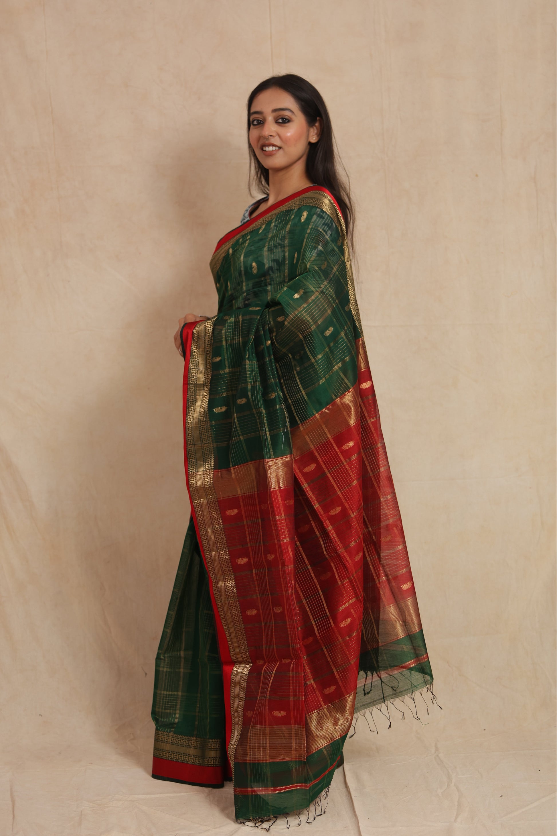 Side profile of green Maheshwari cotton saree with red pallu and tassels