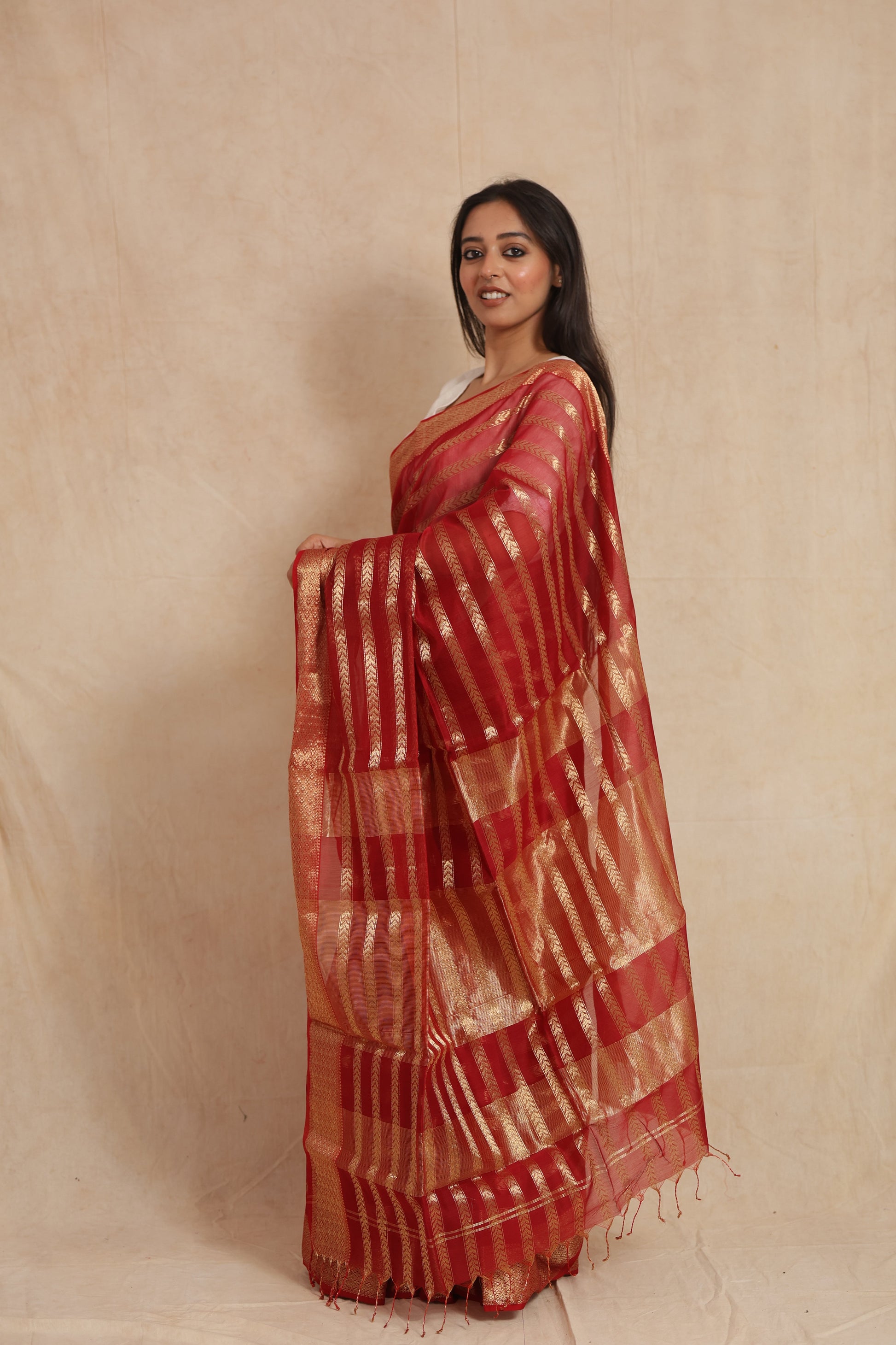 Side profile of ruby red Maheshwari silk tissue saree with gold detailing