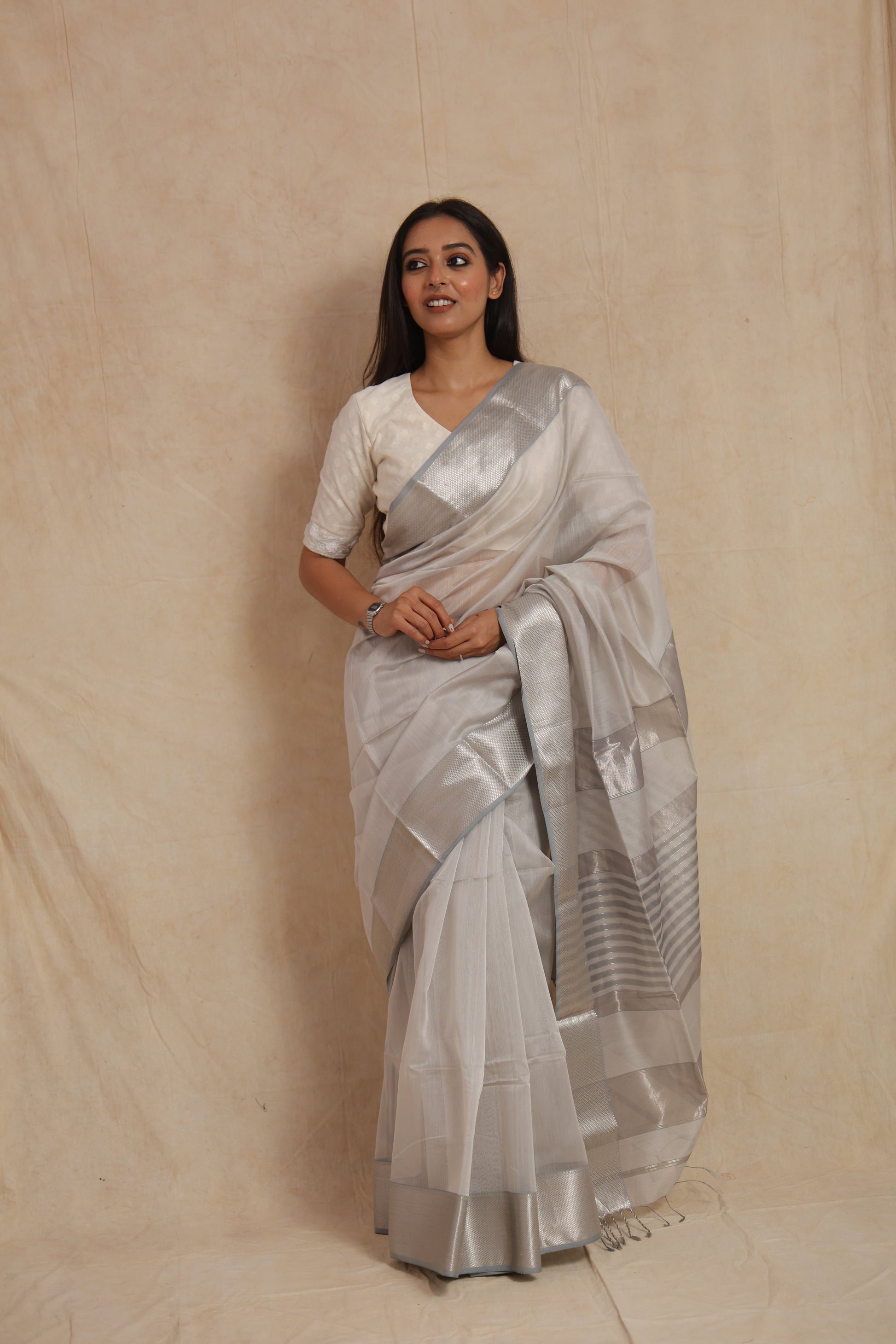 Close-up view of silver woven border on pearl white Maheshwari handloom saree