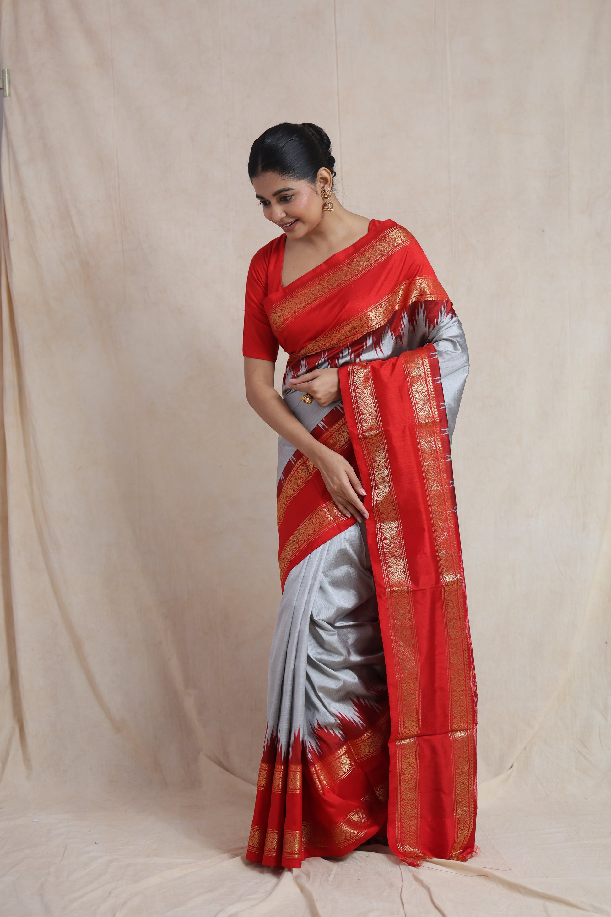 Elegant standing pose in silver grey Panchampali silk saree with red border