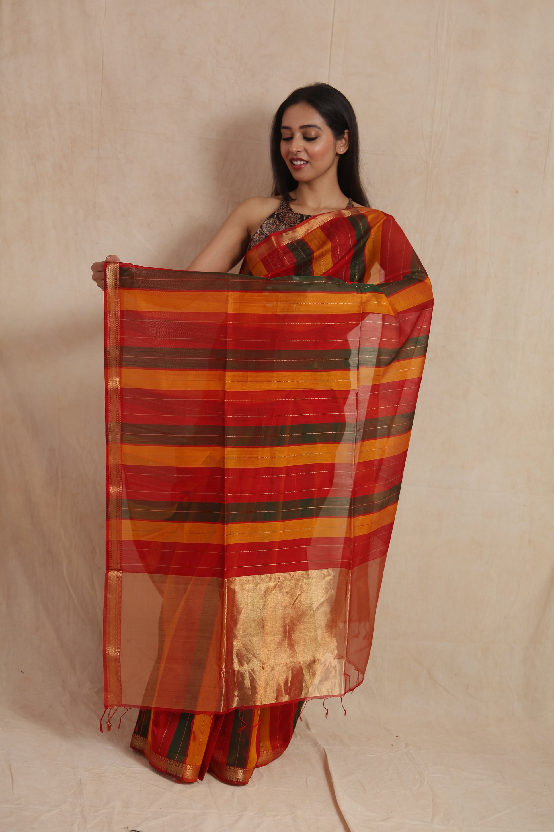Display of striped Maheshwari cotton saree pallu with golden border