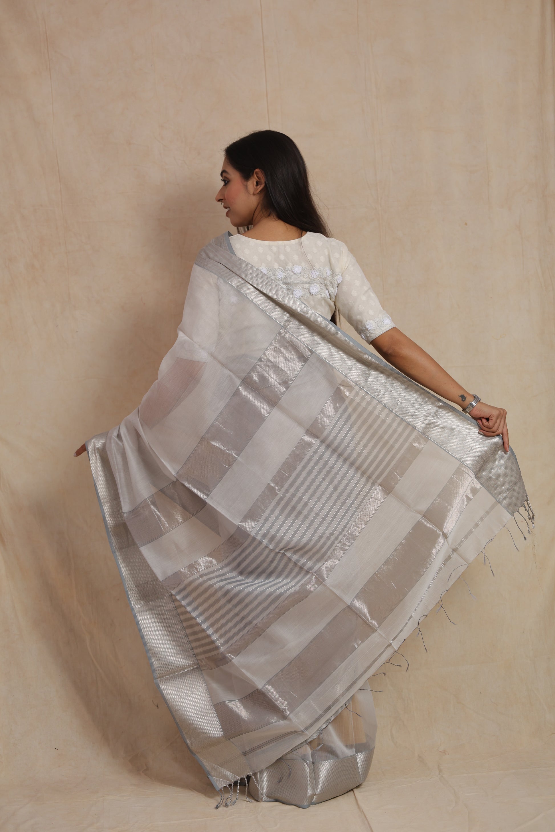 Back pallu view of white Maheshwari silk cotton saree with silver striped detailing