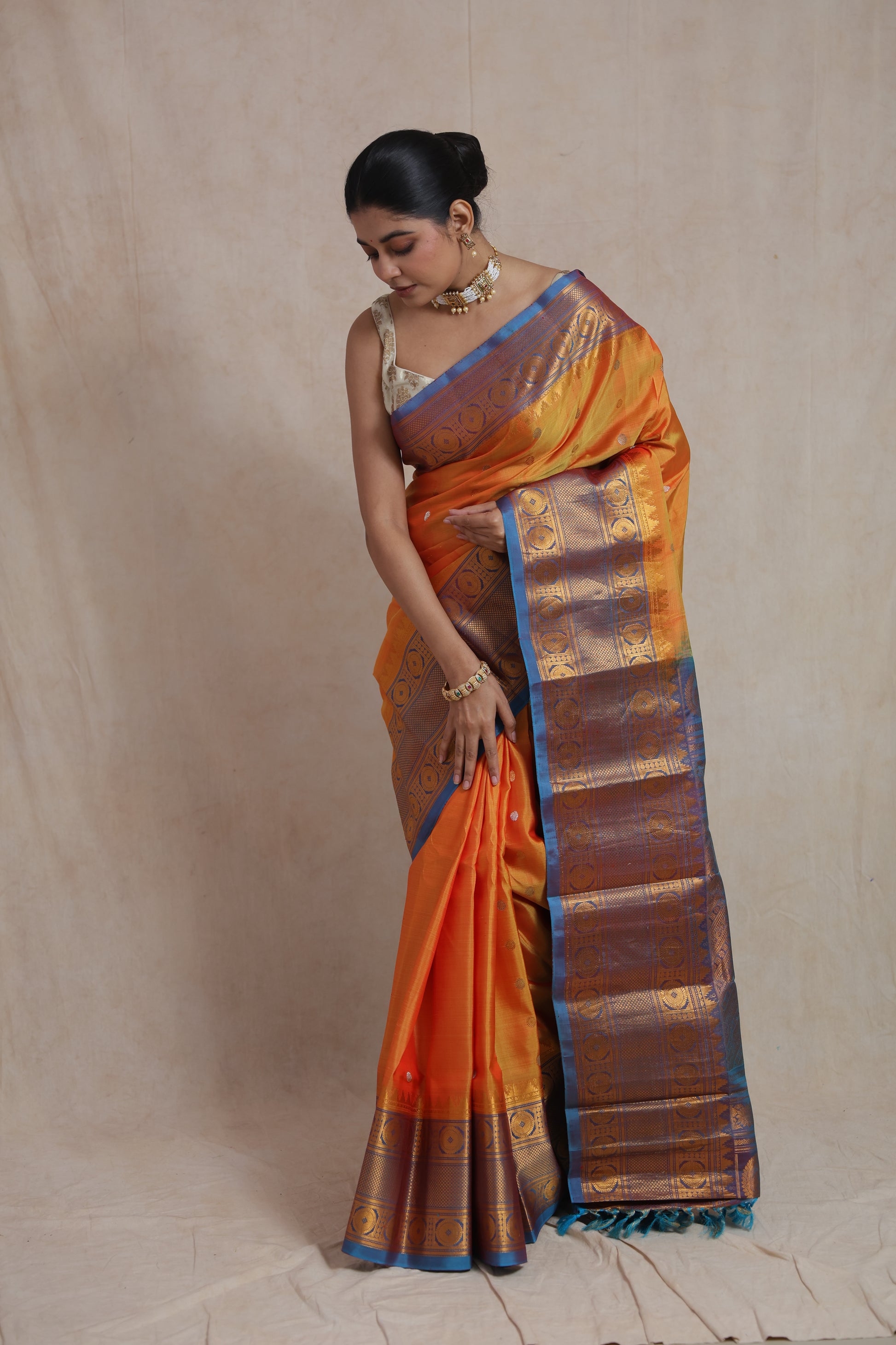 Elegant drape of orange Gadwal silk saree with contrast blue pallu