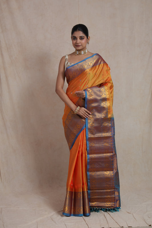 Front view of sunset orange Gadwal silk saree with royal blue zari border