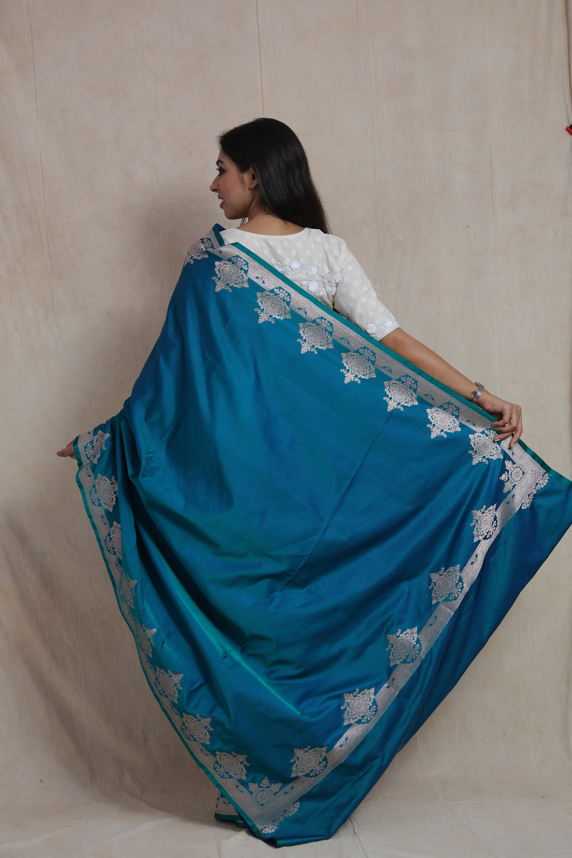 Back pallu view of teal blue Banarasi art silk saree with floral zari border