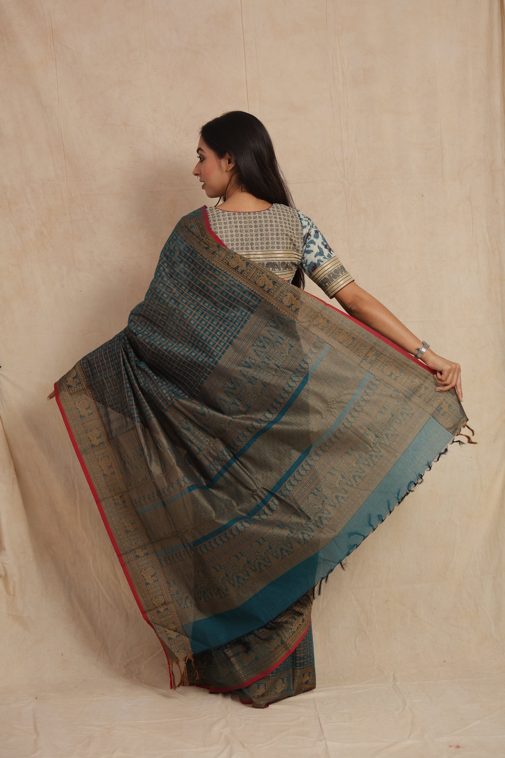 Back pallu view of teal blue Kanchipuram cotton saree with intricate gold zari weaving