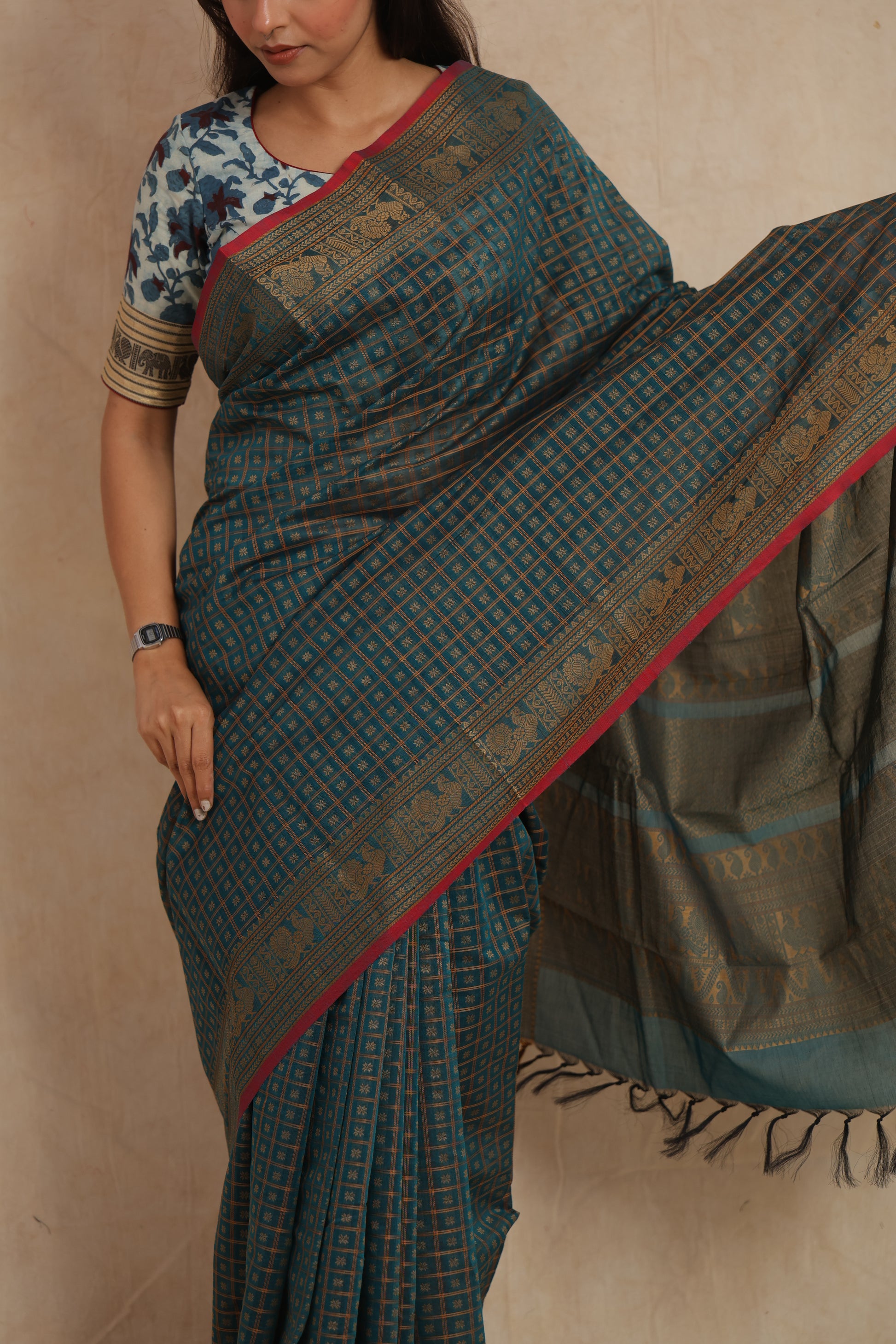 Close-up of teal blue Kanchipuram cotton saree with gold zari check patterns and border