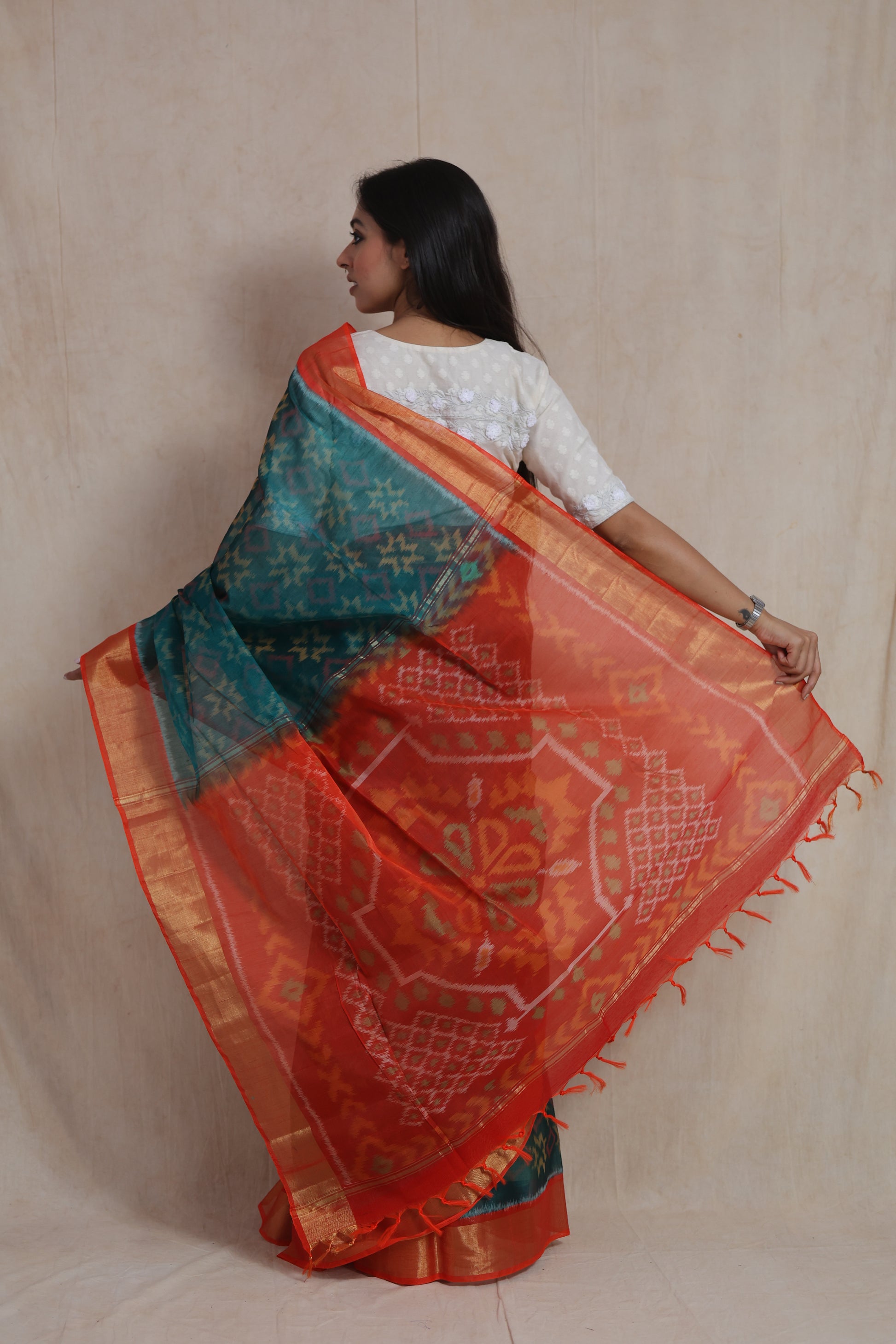 Back view of teal blue and orange Panchampali silk cotton saree with traditional ikat woven pallu