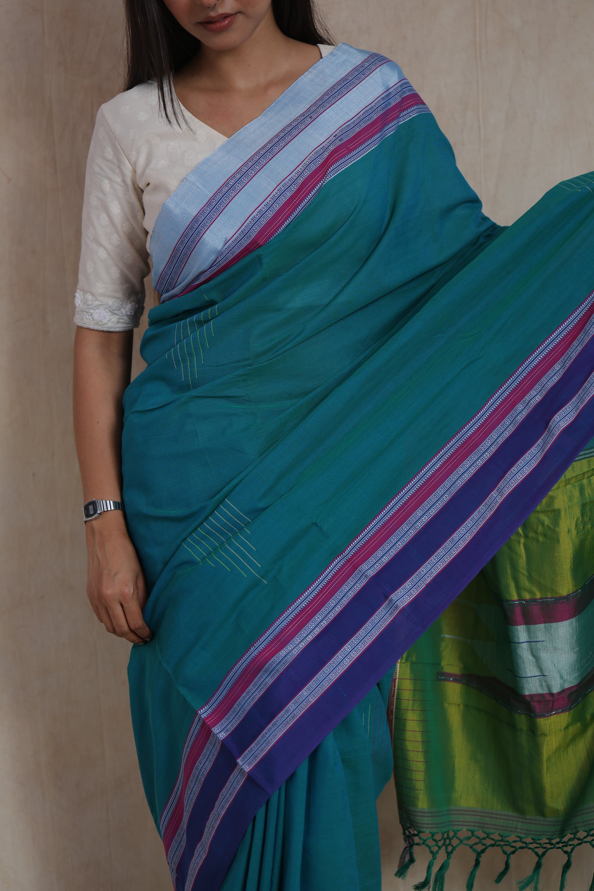 Close-up drape view of teal green Ilkal saree with purple border