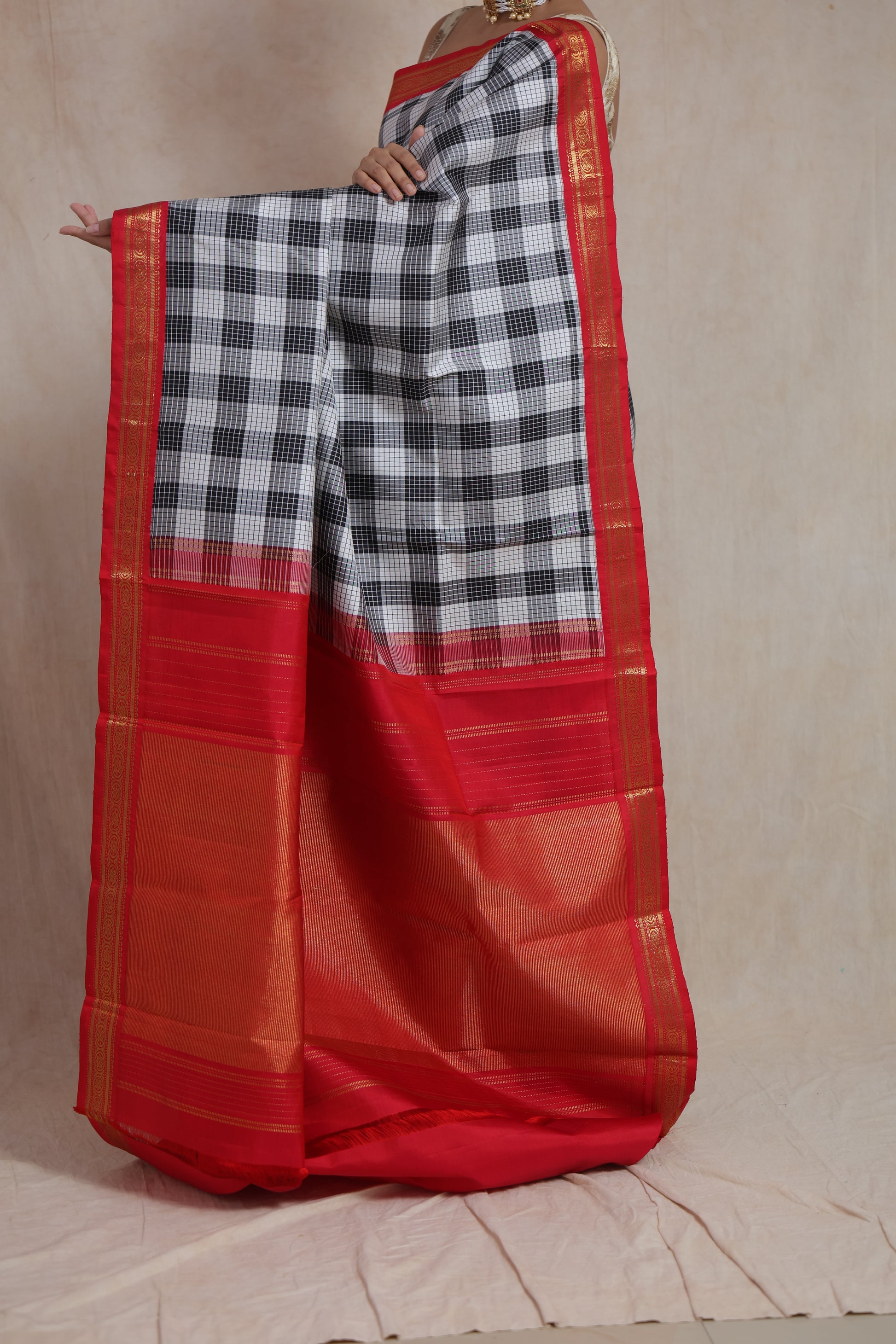 Full pallu view of elegant checked Kanjivaram silk saree with red woven details