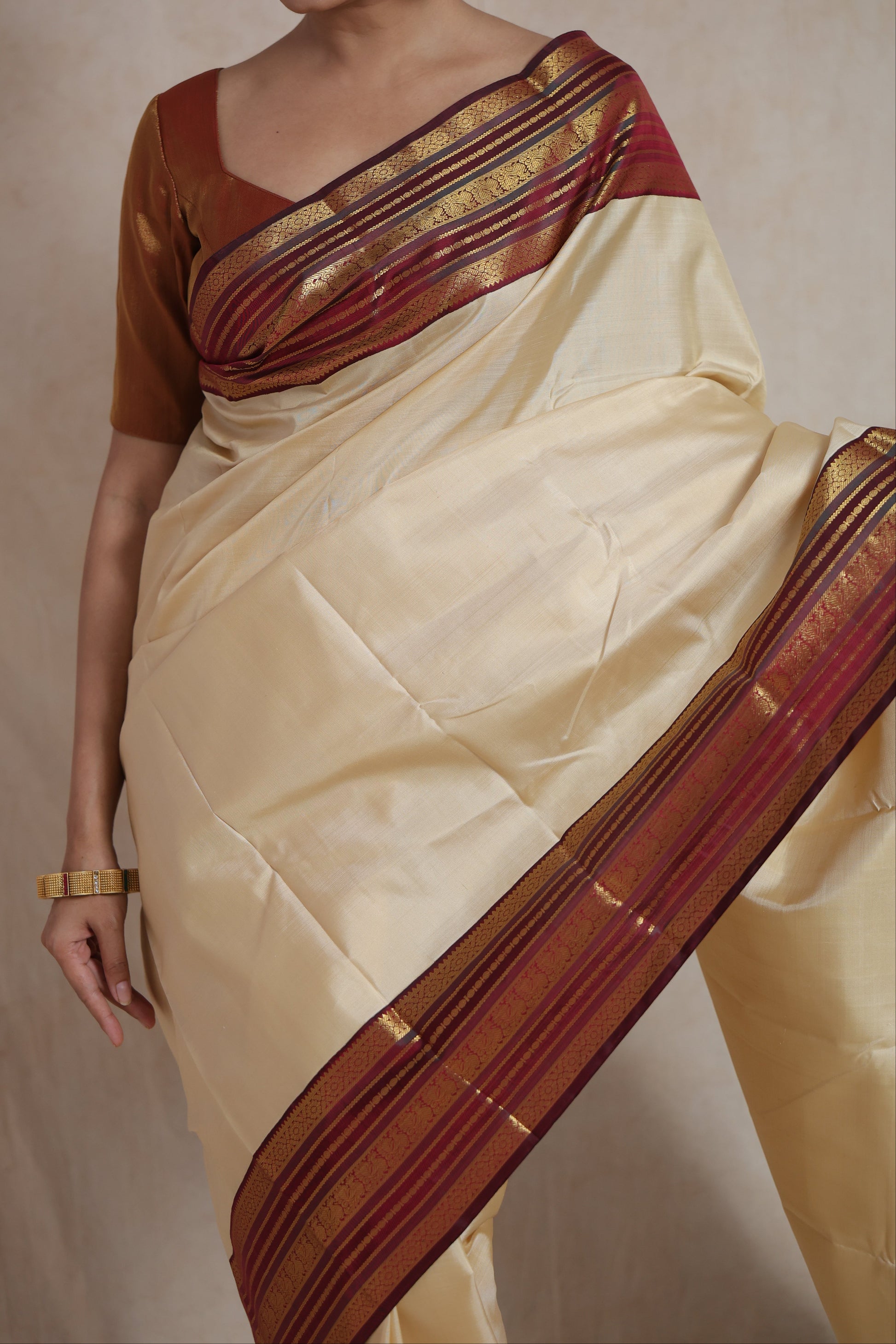 Detailed drape of ivory Kanjivaram pure silk saree with elegant maroon border and heritage woven motifs