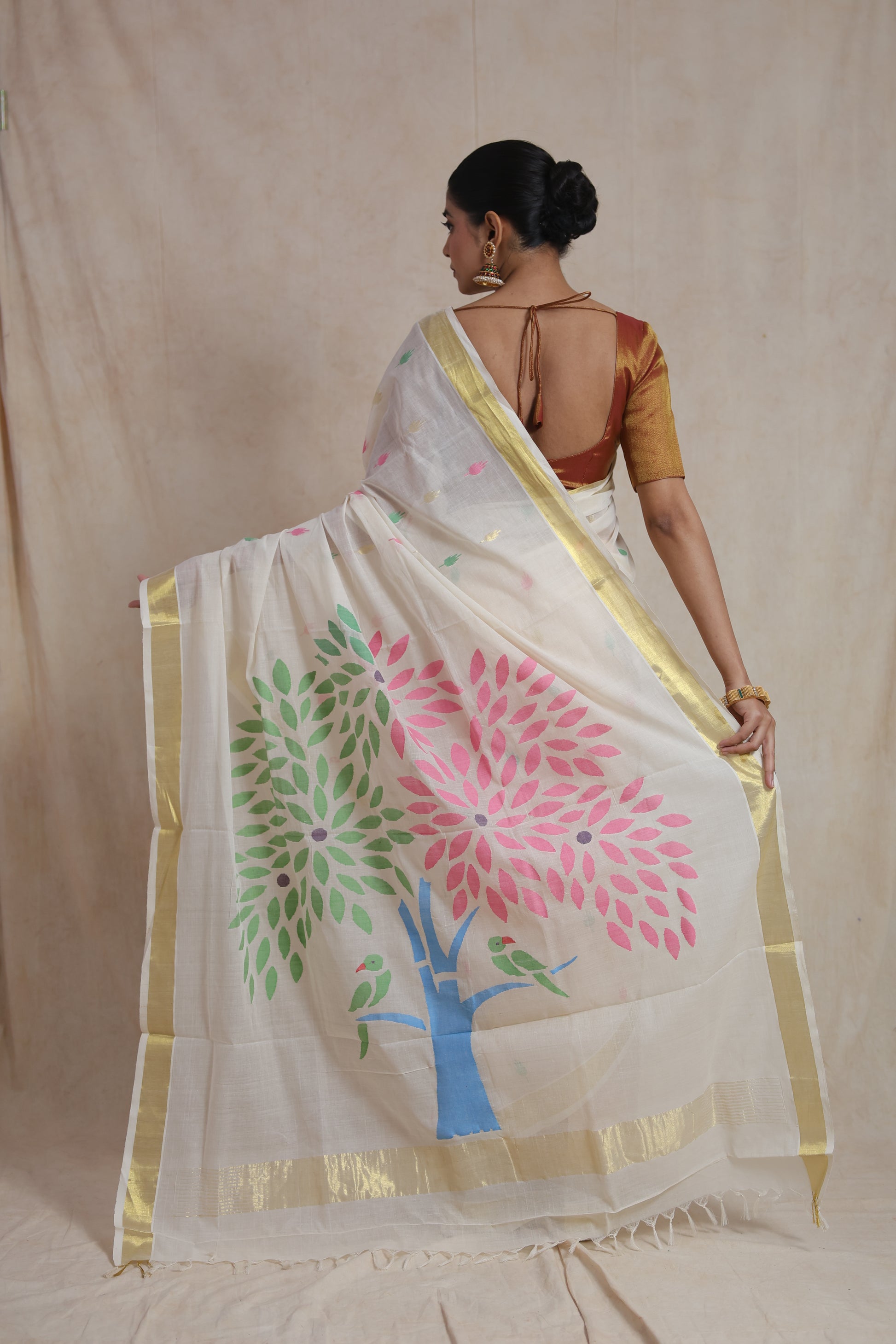 Back view of off white saree showcasing artistic floral pallu design