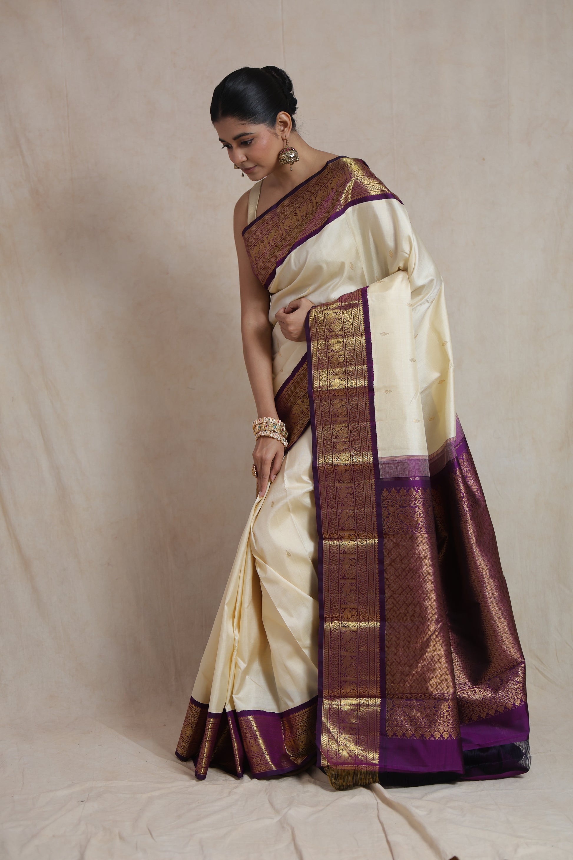 Traditional ivory silk saree with intricate purple zari border