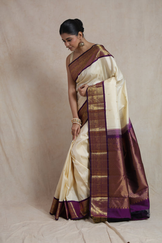 Traditional ivory silk saree with intricate purple zari border