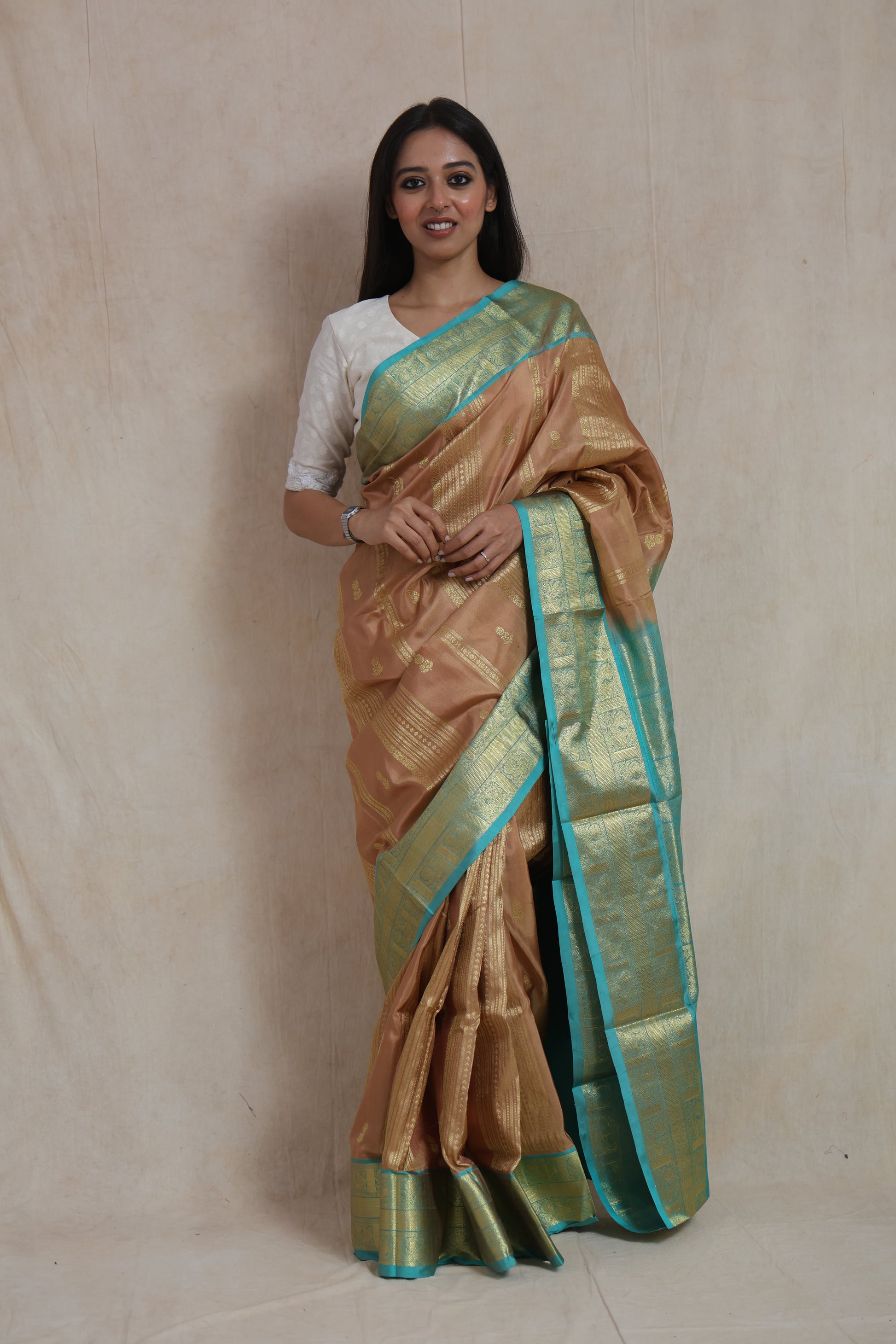 Full-length view of champagne gold Venkatgiri handloom silk saree with aqua blue border and
