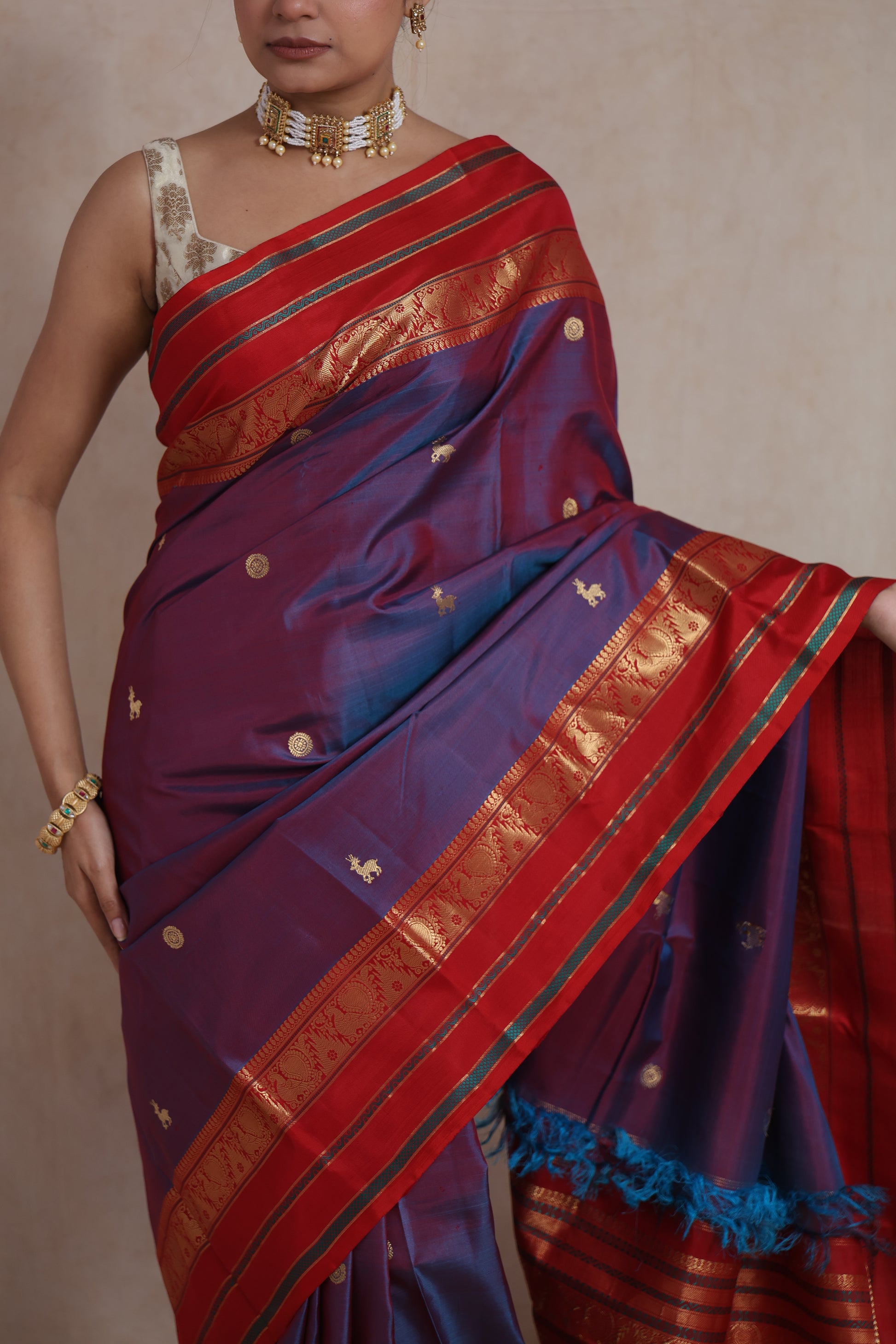 Close-up drape of violet Kanjivaram silk saree with red zari border