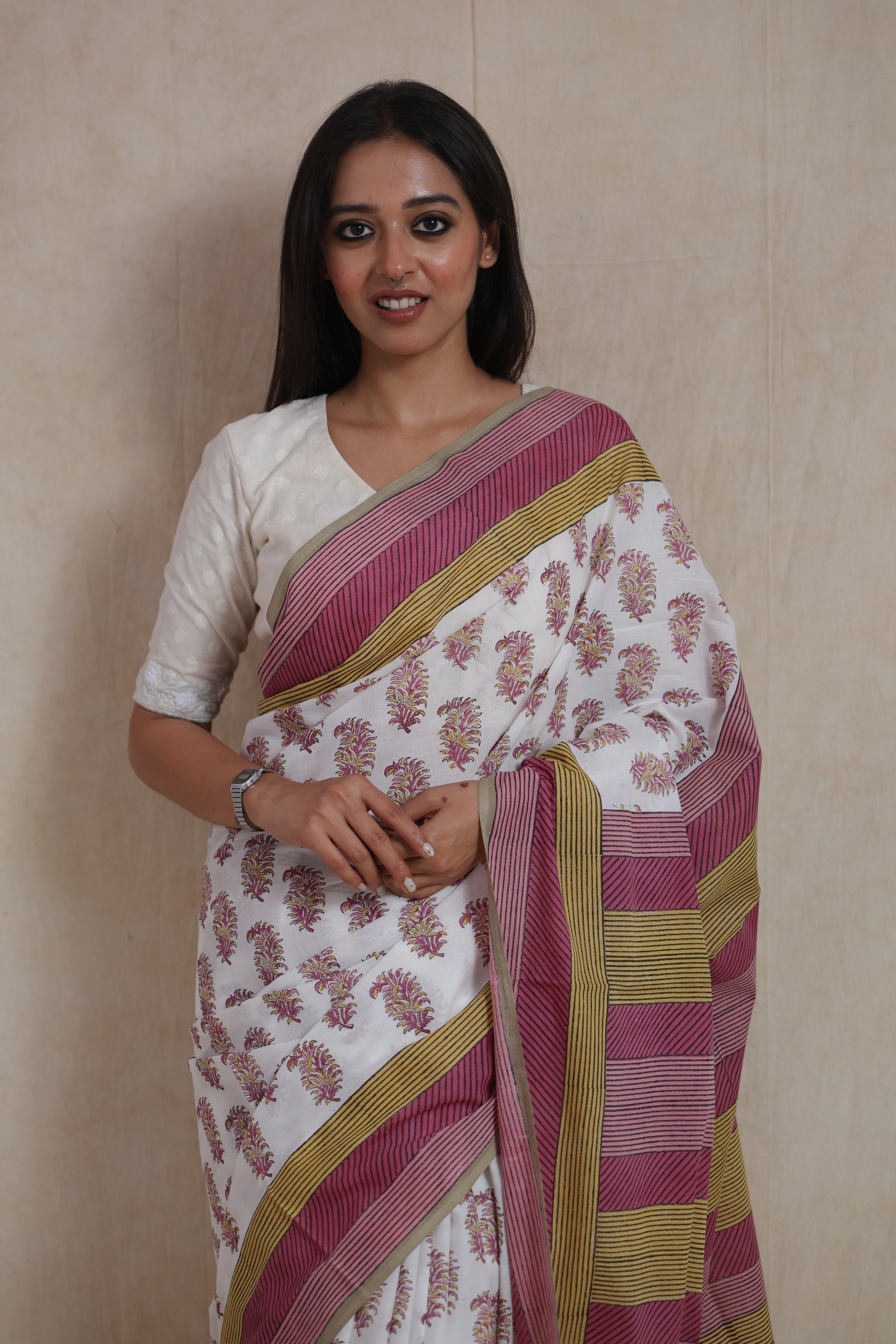 Close-up of white Sanghnaree cotton saree with pink floral prints and striped border