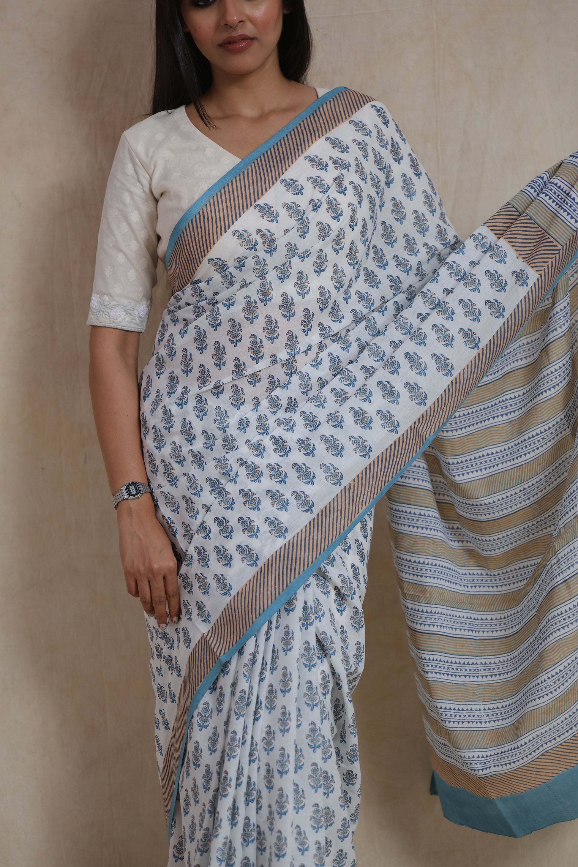 Close-up of white and sky blue Sanghnaree cotton saree with floral buti prints